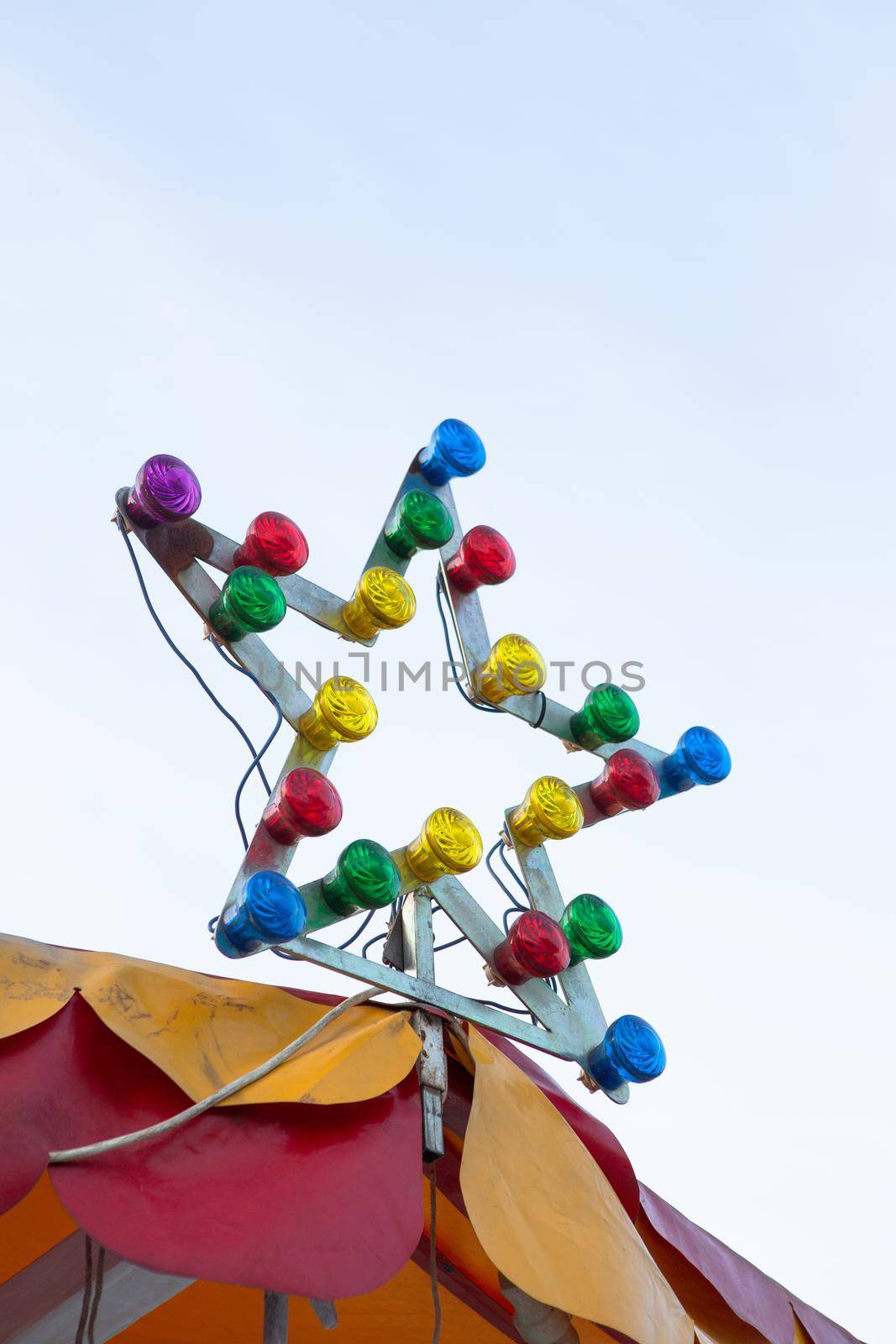 Lamp with multi-colored light bulbs. Star-shaped illumination at the top of the carousel. Illumination concept.