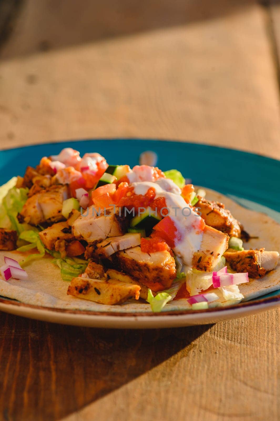 Chicken doner kebab, Turkish style doner kebab sandwich on homemade pita bread with fresh salad and homemade chili sauce and garlic yogurt sauce.