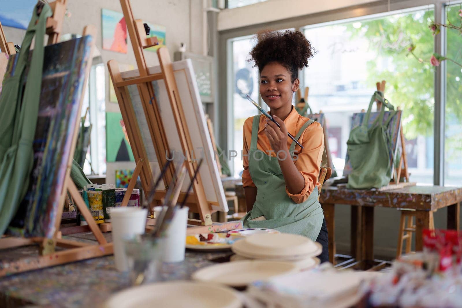 Beautiful american african artist woman painting in art studio at the university classroom by itchaznong