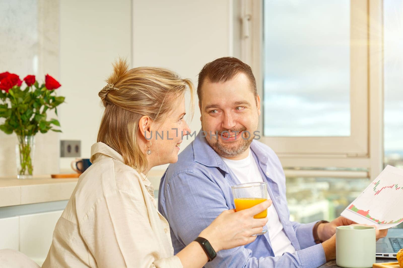 Young beautiful caucasian couple sitting at table while having breakfast at home Happy couple having breakfast together before leaving to work