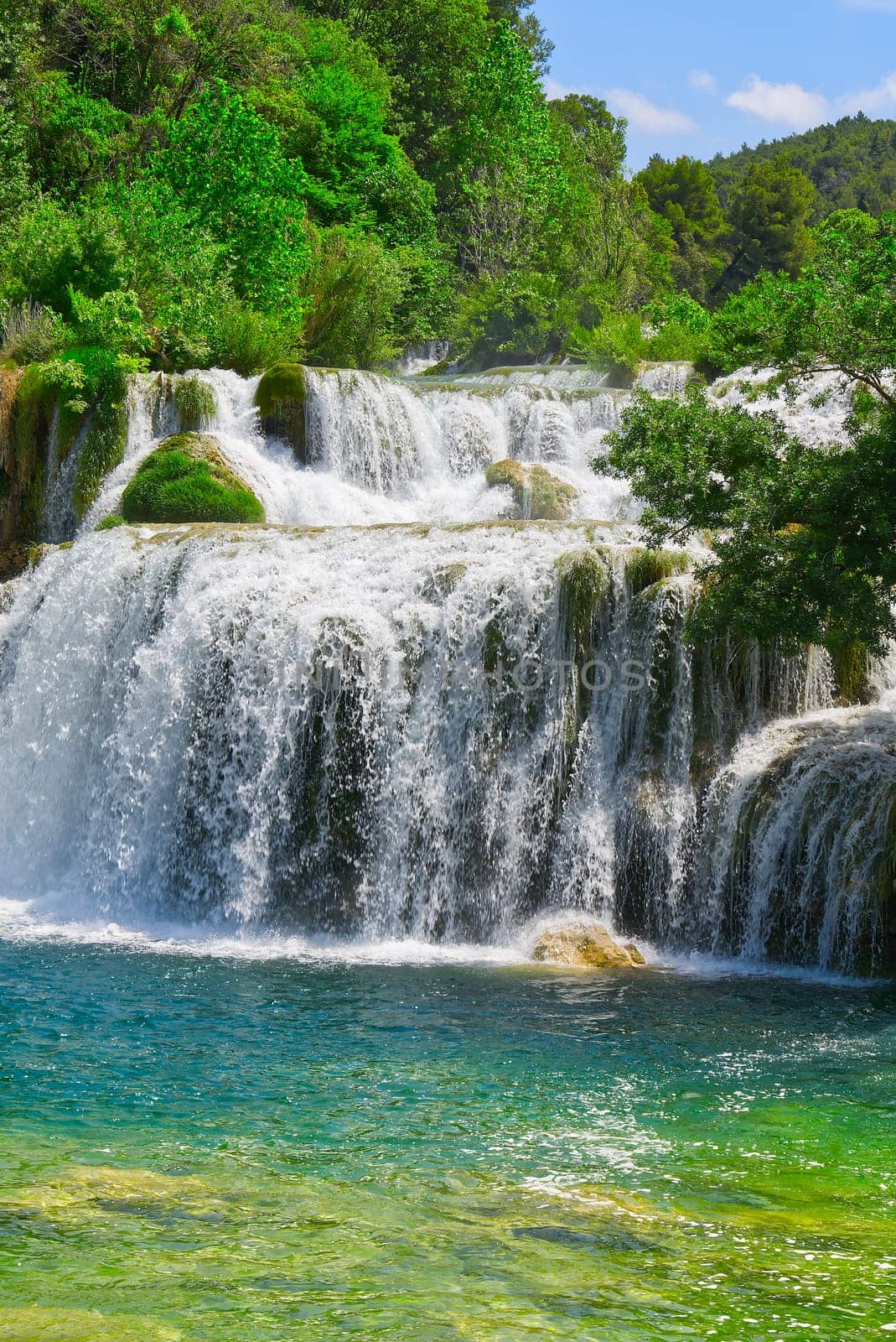 Beautiful Waterfall background in sunny summer day. Beautiful Waterfall In Krka National Park - Croatia, Europe. Krka river waterfalls in the Krka National Park