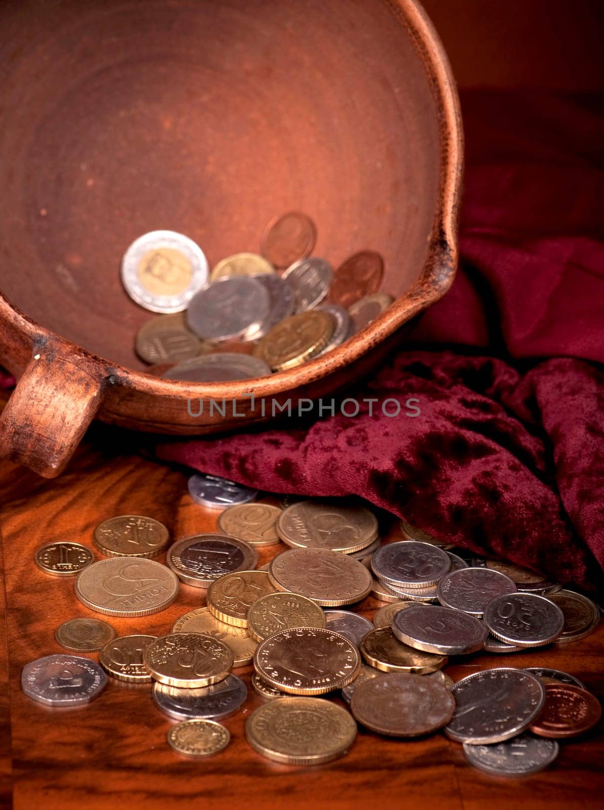 Vintage background with coins, velvet background and pottery. Money of different countries is combined in clay bowl. by aprilphoto