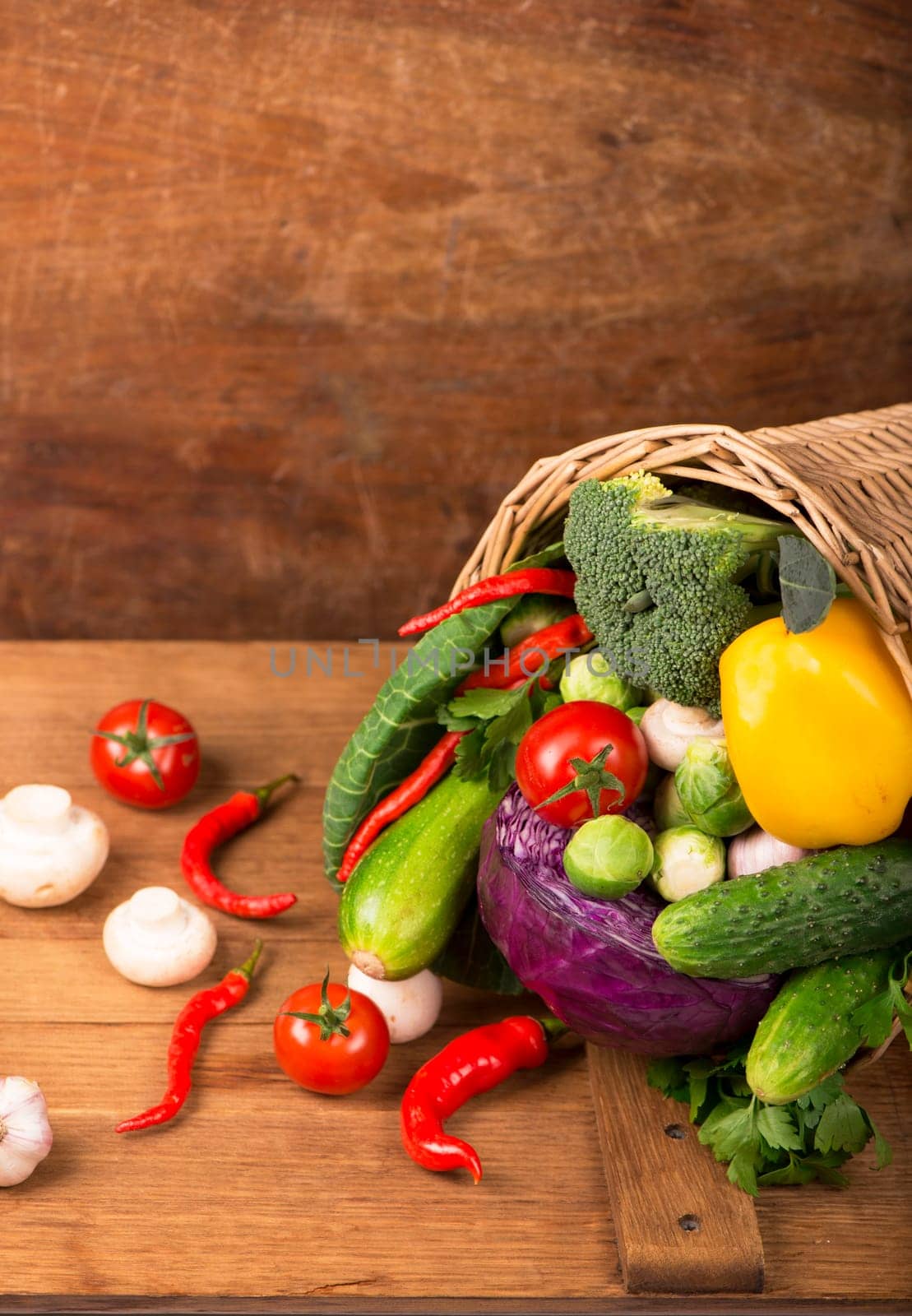 Top view of vegetables on wooden table and wicker basket, carrots velery tomatoes cabbage broccoli, copy space, selective focus by aprilphoto