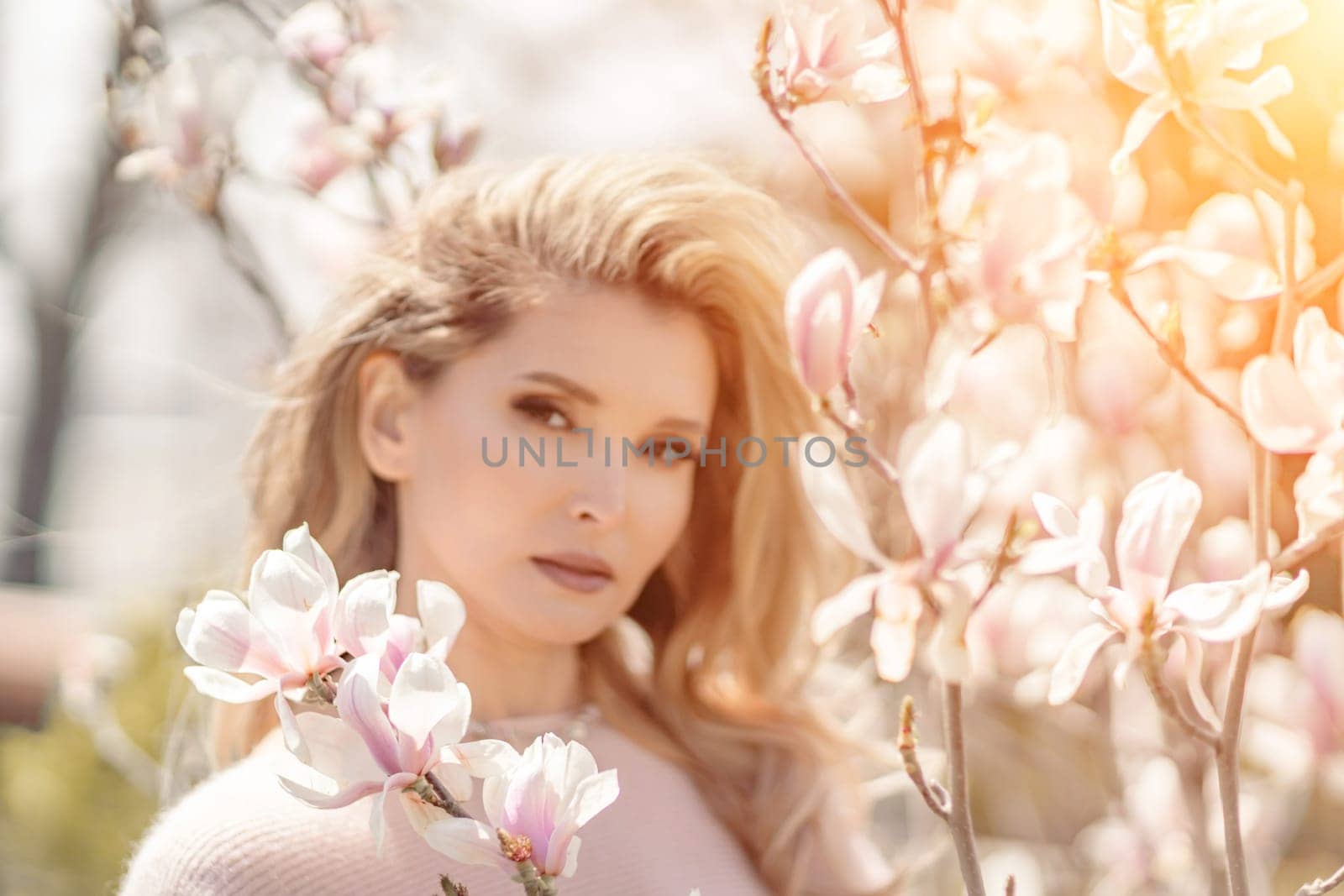 Magnolia woman portrait. Happy middle aged woman enjoying the smell in a blooming spring garden. Beautiful magnolia bushes, large flowers. by Matiunina