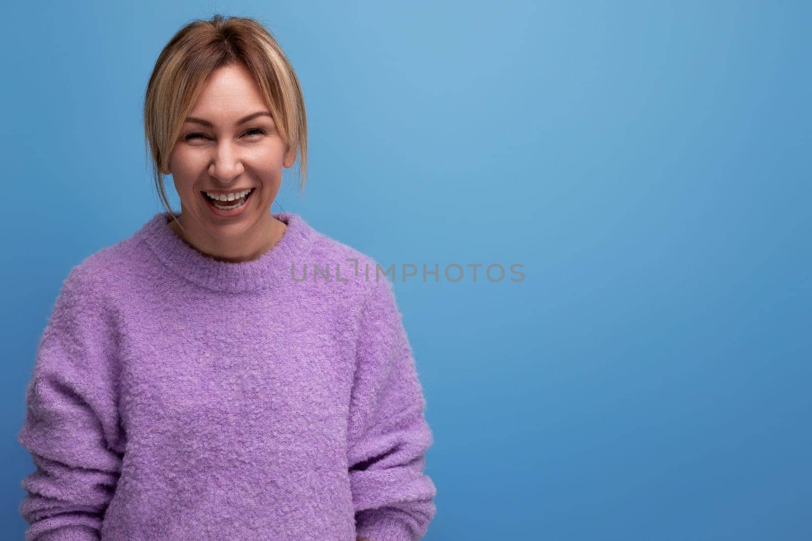 smiling stylish blond young woman in a casual look with a good mood on a bright background with copy space.