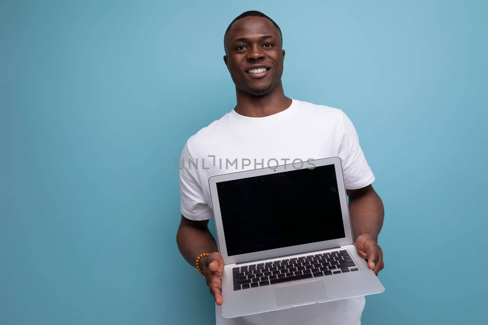 30 year old American male adult in a white t-shirt demonstrates a promotional offer on a screen.