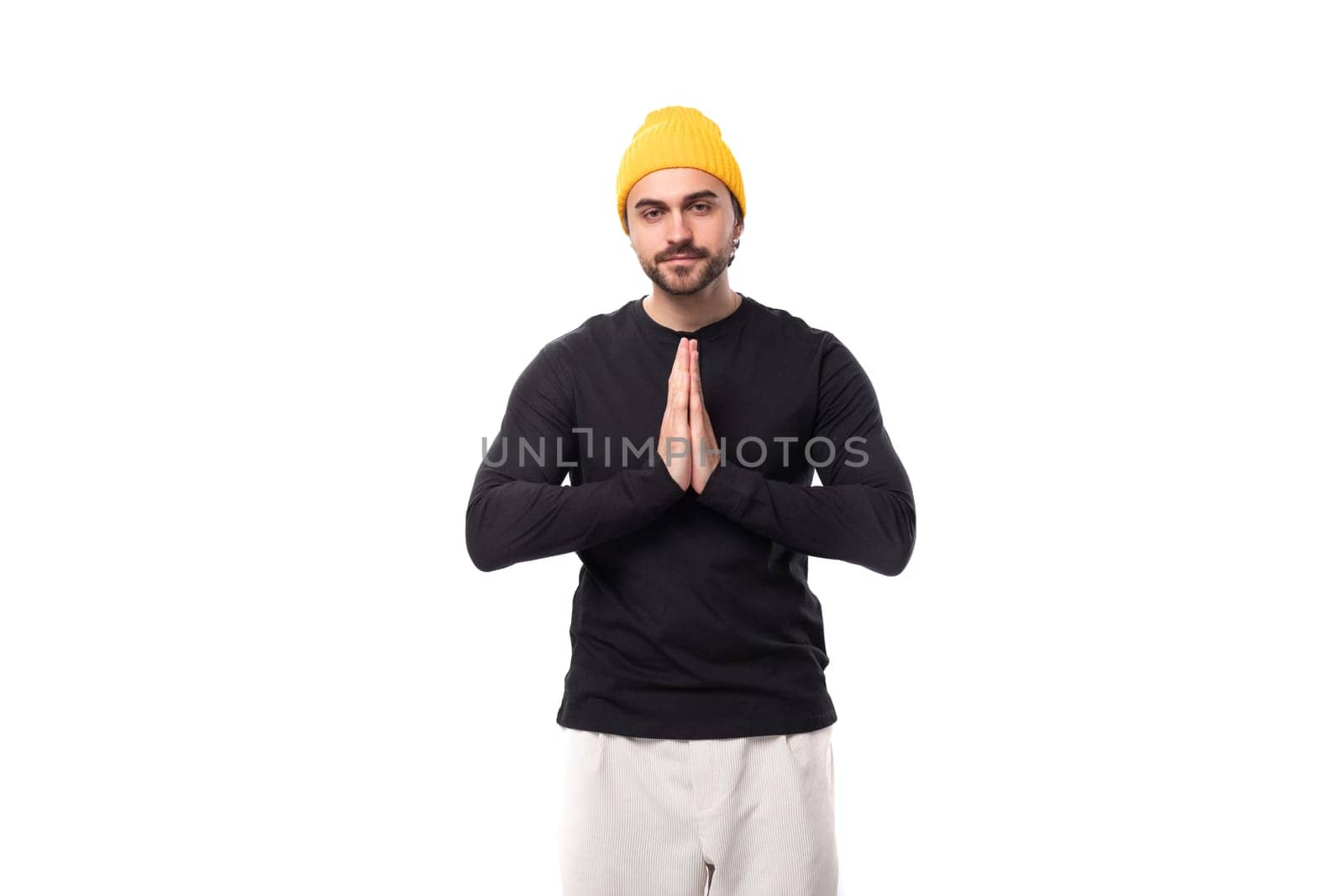 young hopeful brunet european brutal man in black sweatshirt on white background with copy space by TRMK