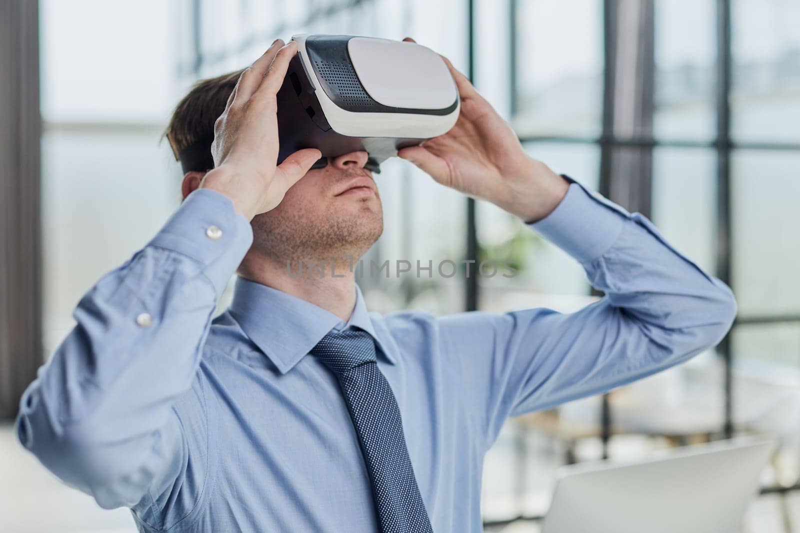 young man testing VR glasses or goggles sitting in the office room