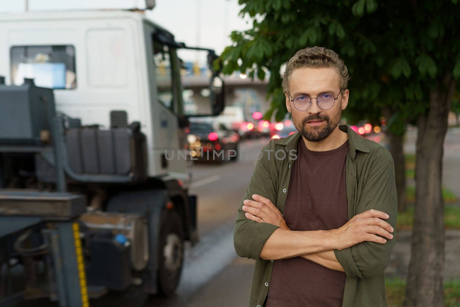 Depressed man with crossed hands against backdrop of truck, symbolizing concept of illegal parking. Truck background represents consequences and potential enforcement of parking violations. by LipikStockMedia