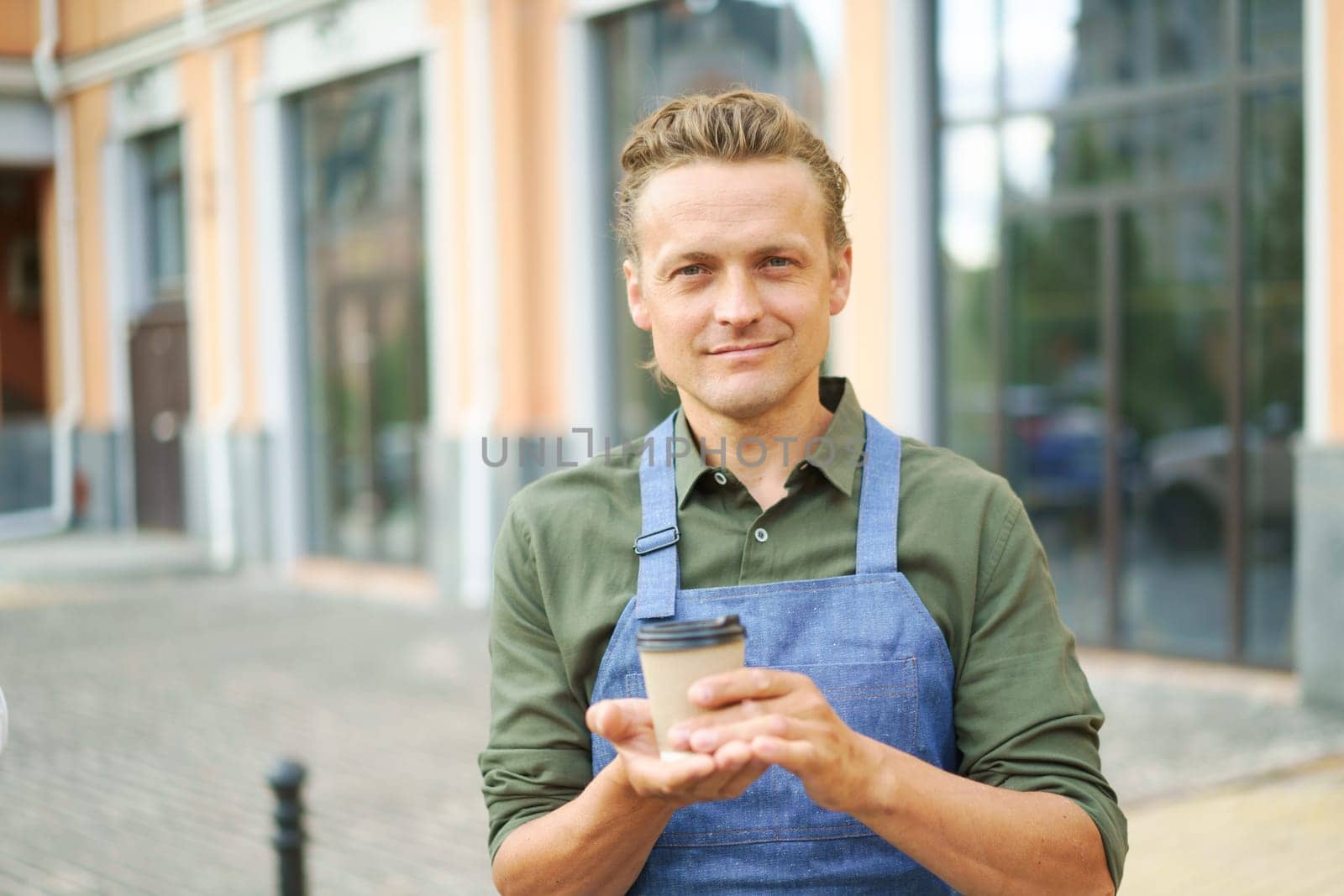 Concept of coffee on the go as waiter offers hot paper cup of coffee to client on street. Urban hospitality and the convenience of enjoying a freshly brewed coffee while on the move. . High quality photo
