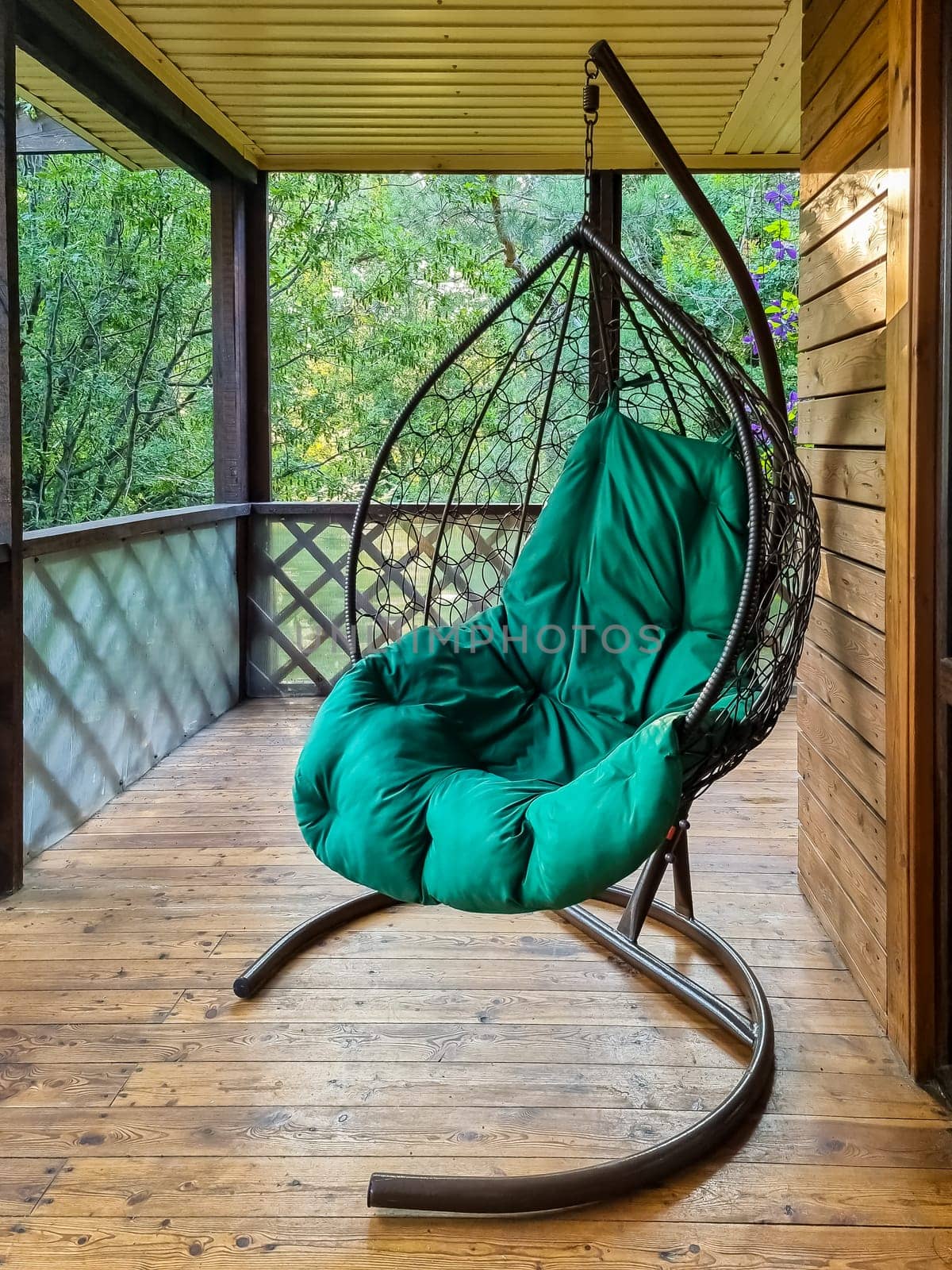 The concept of relaxing with a hammock chair on the balcony or terrace. Cozy rest in a cafe.