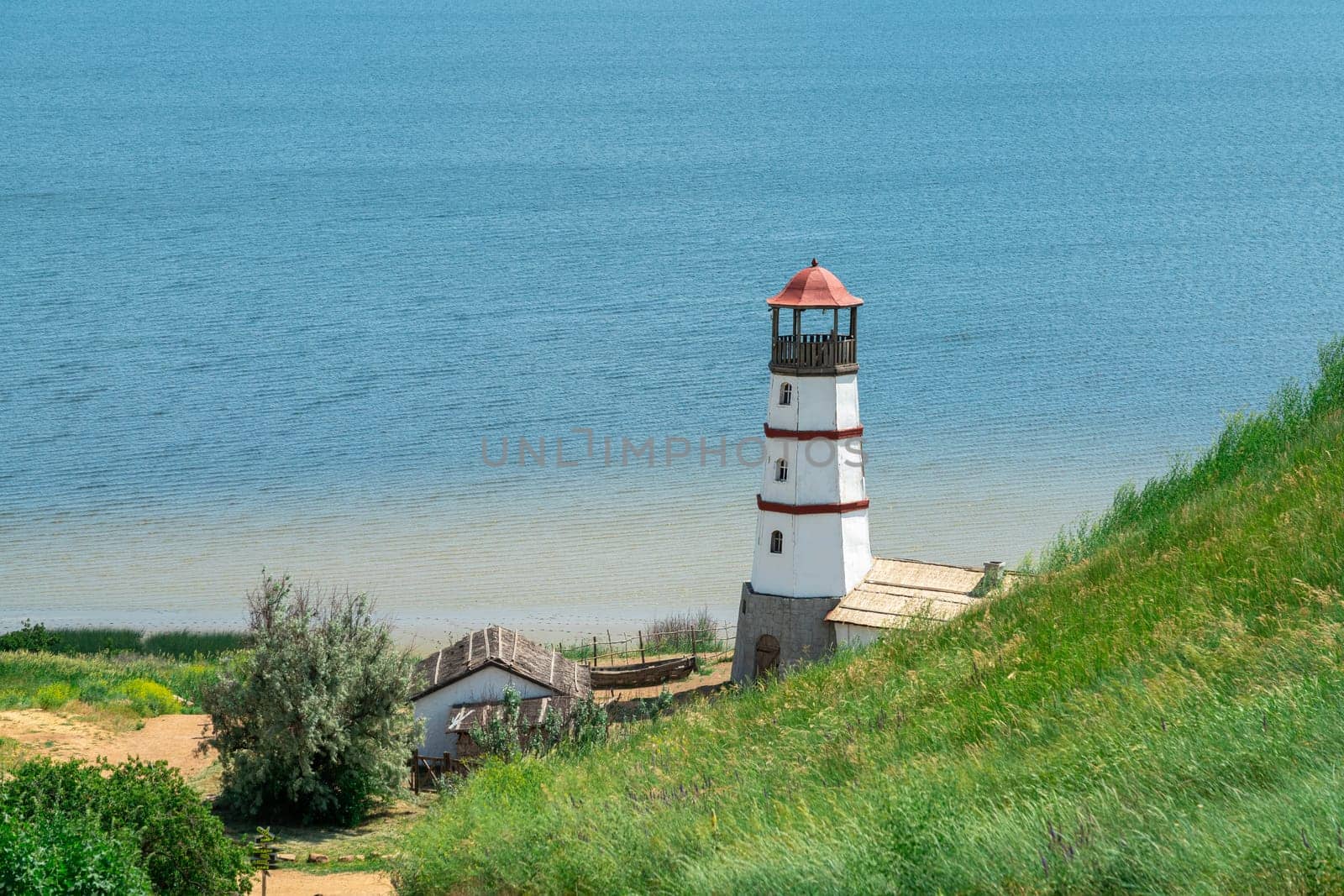 the old lighthouse against the blue sky by roman112007