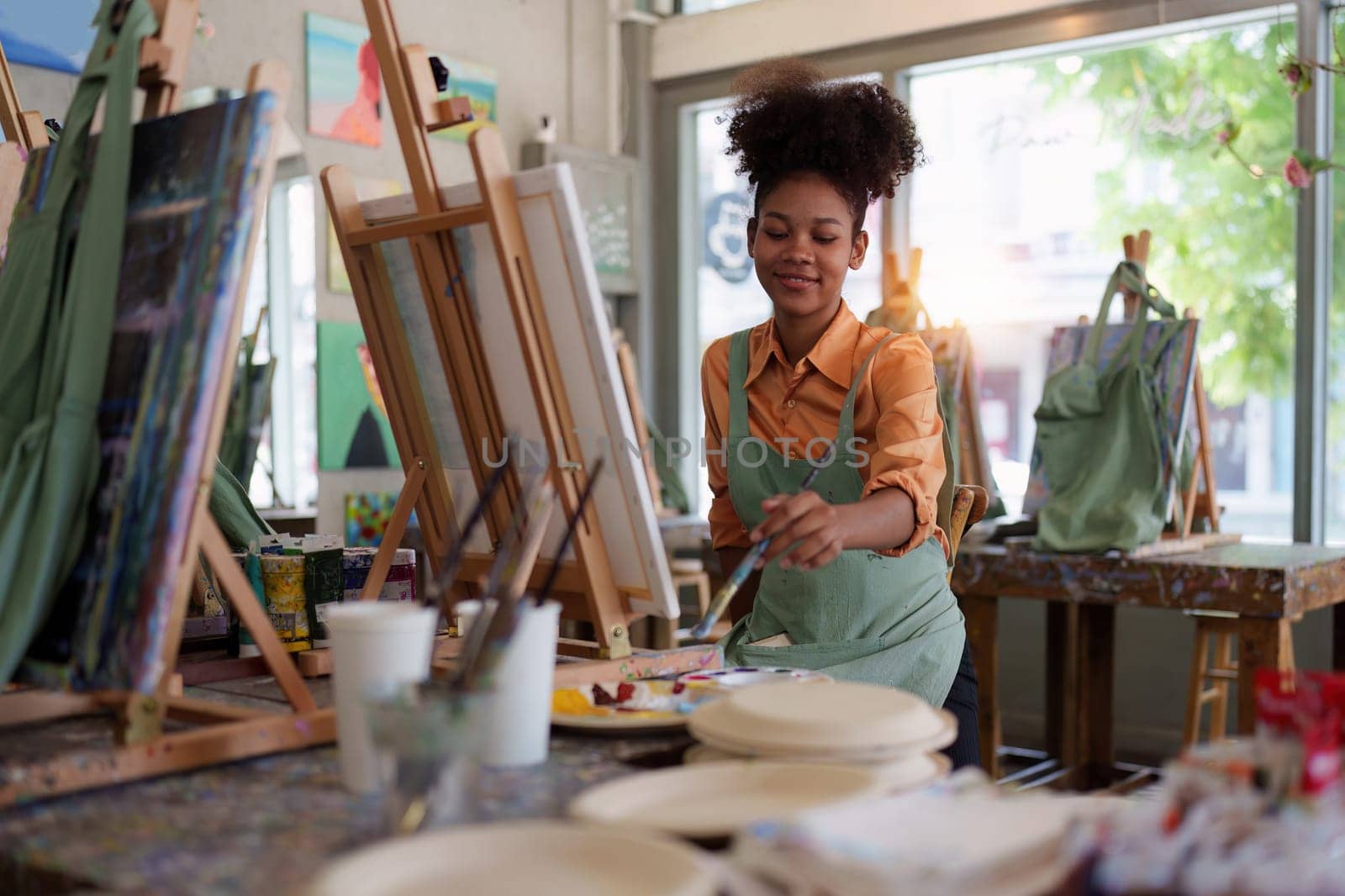 Beautiful american african artist woman painting in art studio at the university classroom by itchaznong