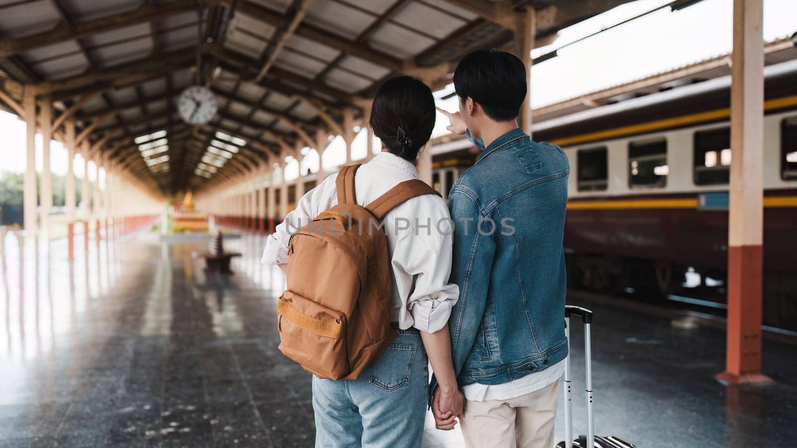 Asian couple at railway station have happy moment. Tourism and travel in the summer.