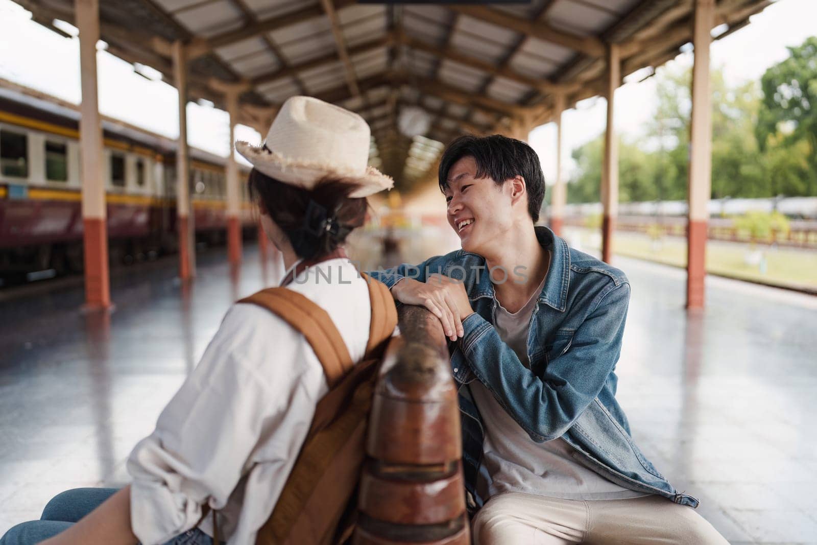 Asian couple at railway station have happy moment. Tourism and travel in the summer by itchaznong