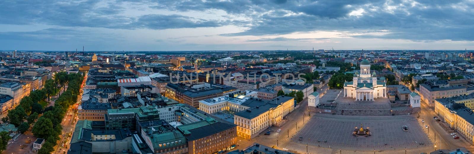 Lit streets and buildings by church and square in European city at dawn. High quality photo