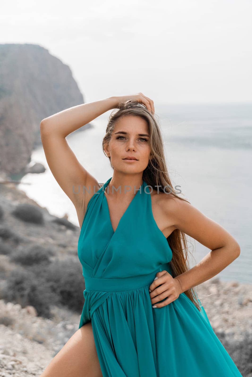 Woman sea green dress. Side view a happy woman with long hair in a long mint dress posing on a beach with calm sea bokeh lights on sunny day. Girl on the nature on blue sky background. by Matiunina