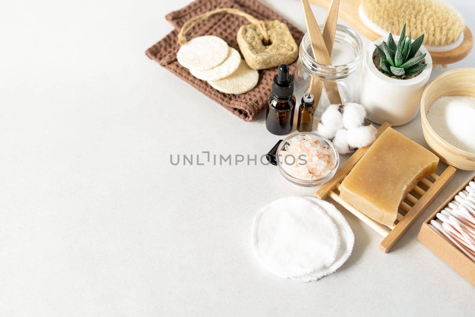Natural bathroom and home spa tools. Zero waste sustainable lifestyle concept. Bamboo toothbrush, natural soap bar, cotton pads, homemade DIY beauty products in reusable bottles on white background by Ostanina
