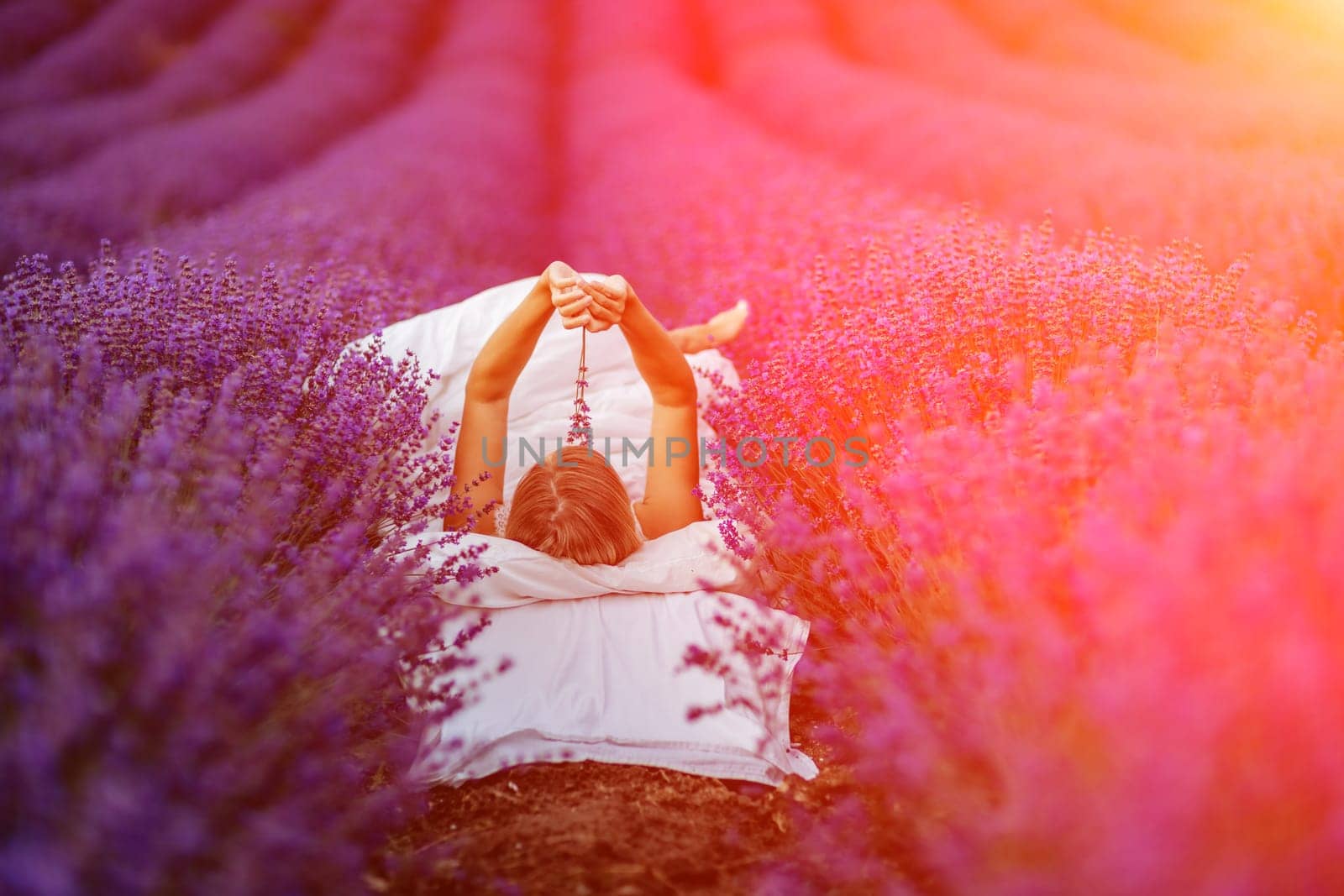 Woman lavender field. A middle-aged woman lies in a lavender field and enjoys aromatherapy. Aromatherapy concept, lavender oil, photo session in lavender.