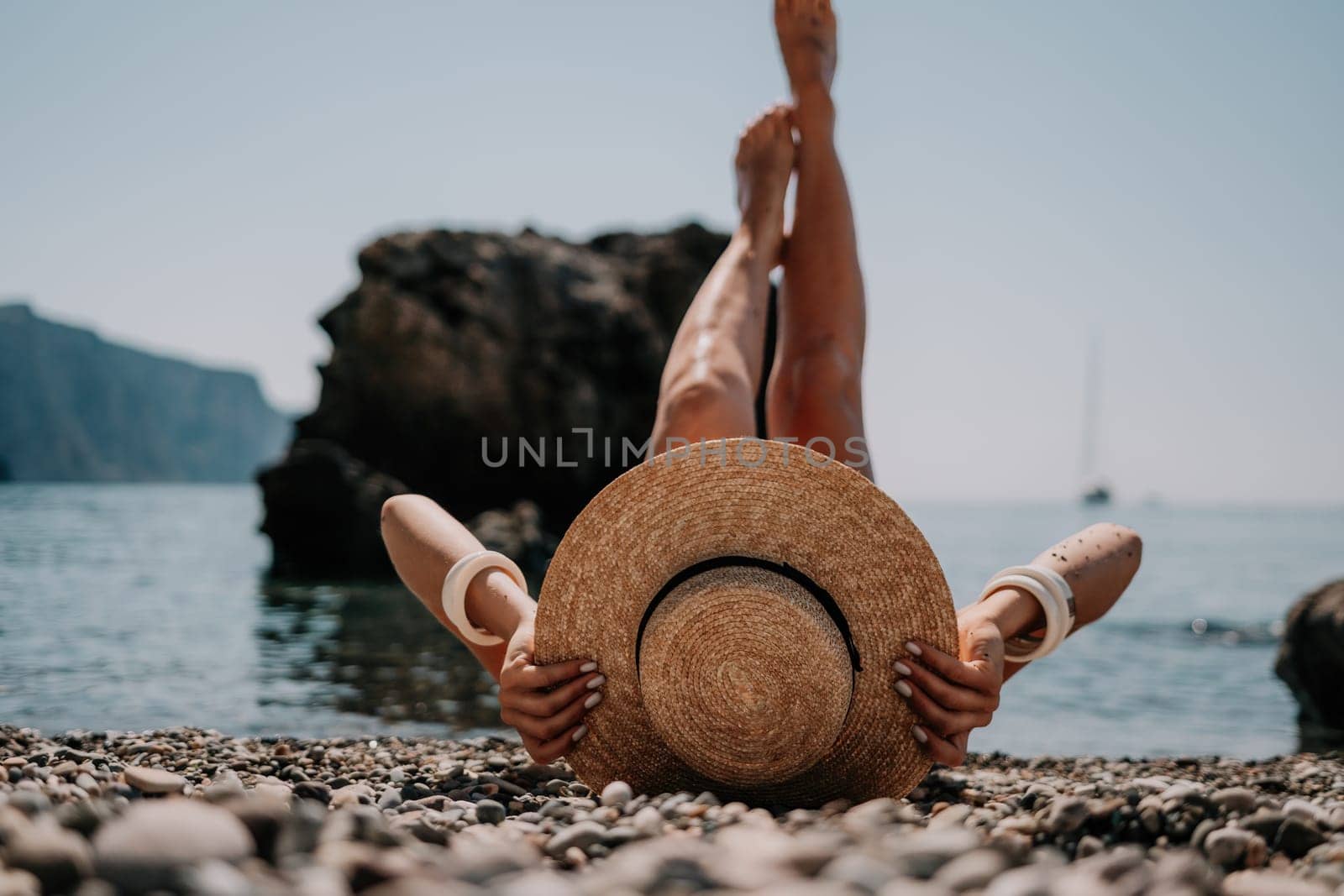 Woman travel sea. Happy tourist in hat enjoy taking picture outdoors for memories. Woman traveler posing on the beach at sea surrounded by volcanic mountains, sharing travel adventure journey by panophotograph