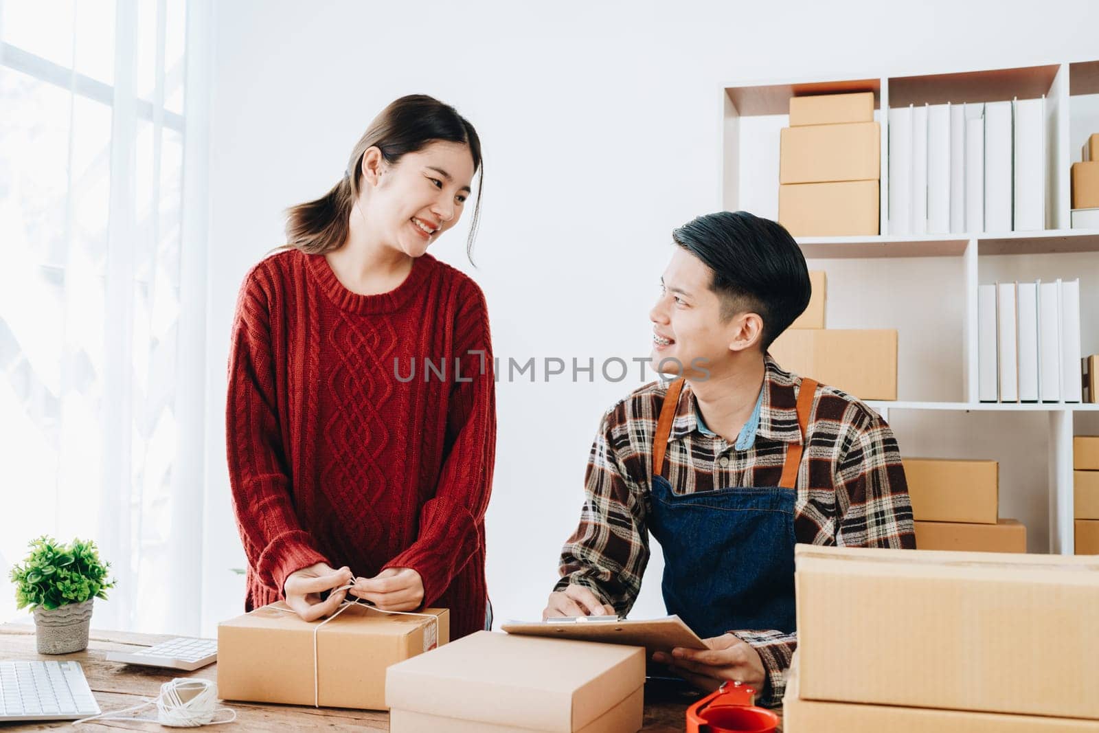 Portrait of Starting small businesses SME owners, family business check online orders Selling products working with boxes freelance work at home office, sme business online small medium enterprise.