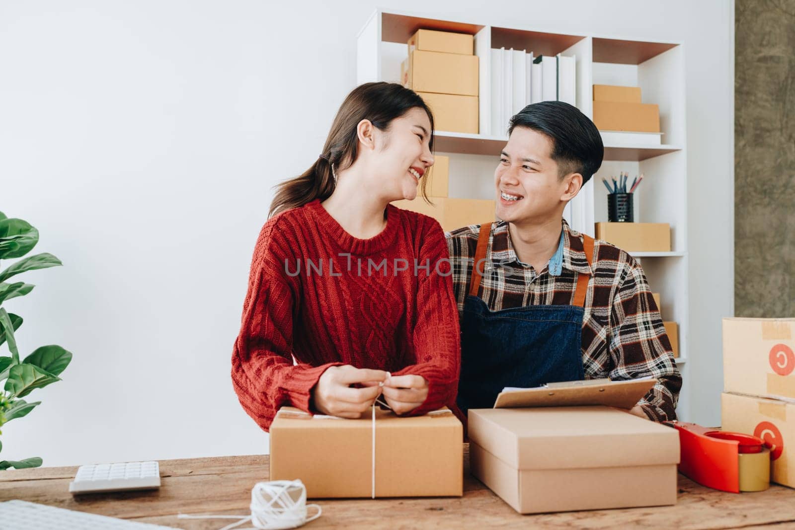 Portrait of Starting small businesses SME owners, family business check online orders Selling products working with boxes freelance work at home office, sme business online small medium enterprise by Manastrong