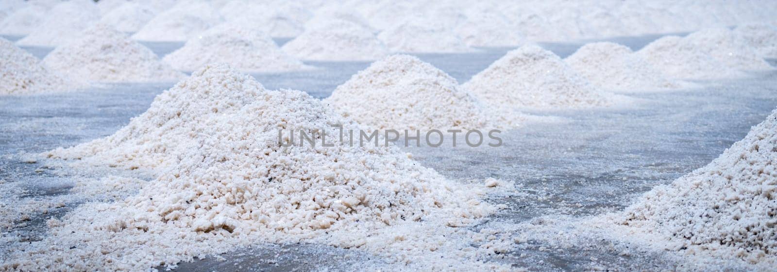 Sea salt farm. Pile of brine salt. Raw material of salt industrial. Sodium Chloride mineral. Evaporation and crystallization of sea water. White salt harvesting. Agriculture industry. Traditional farm by Fahroni