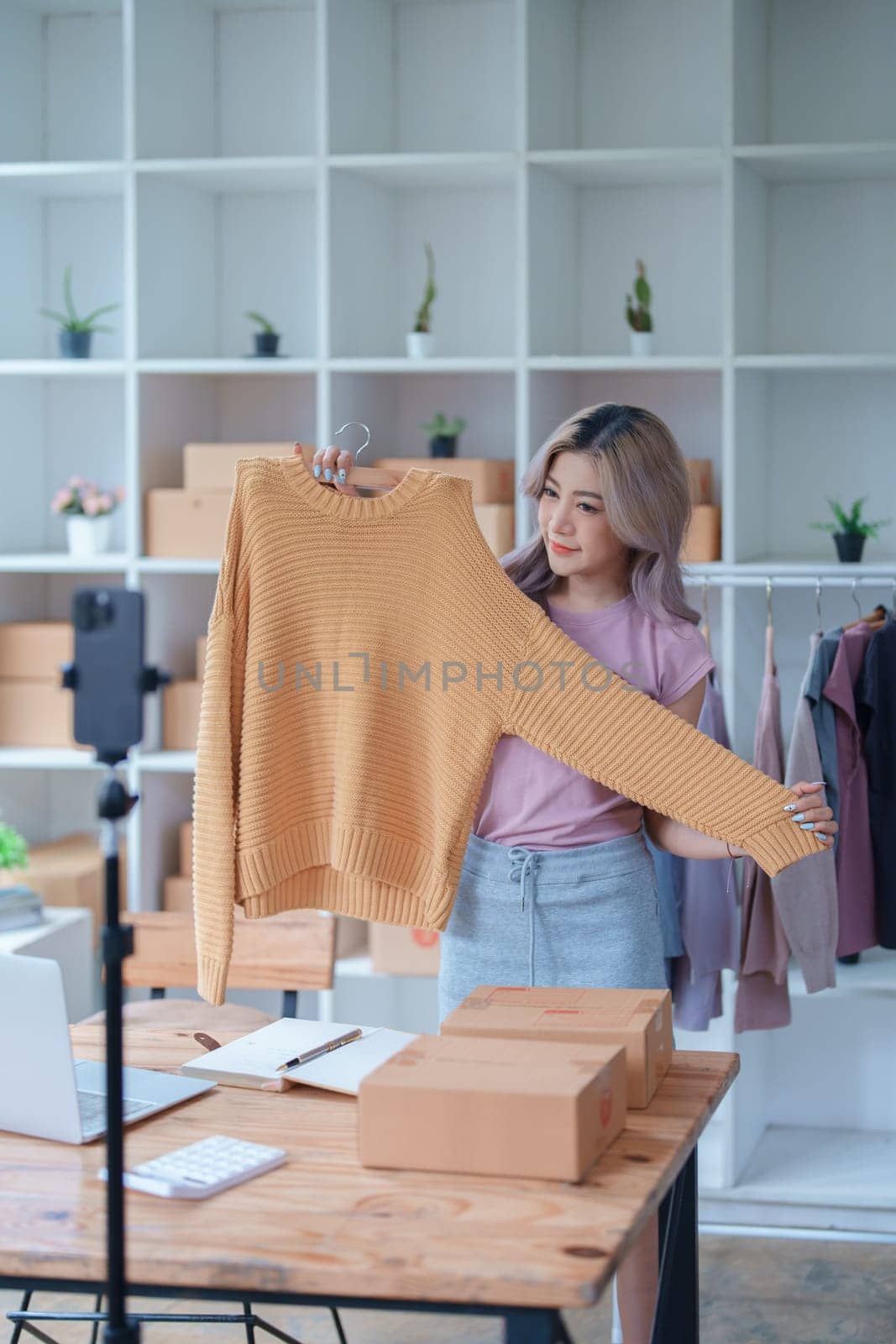 Beautiful Asian woman, blogger, blog, presenting fashion clothes, live video, social media, record her, sell online via digital cameras, sme or small business ecommerce concepts by Manastrong