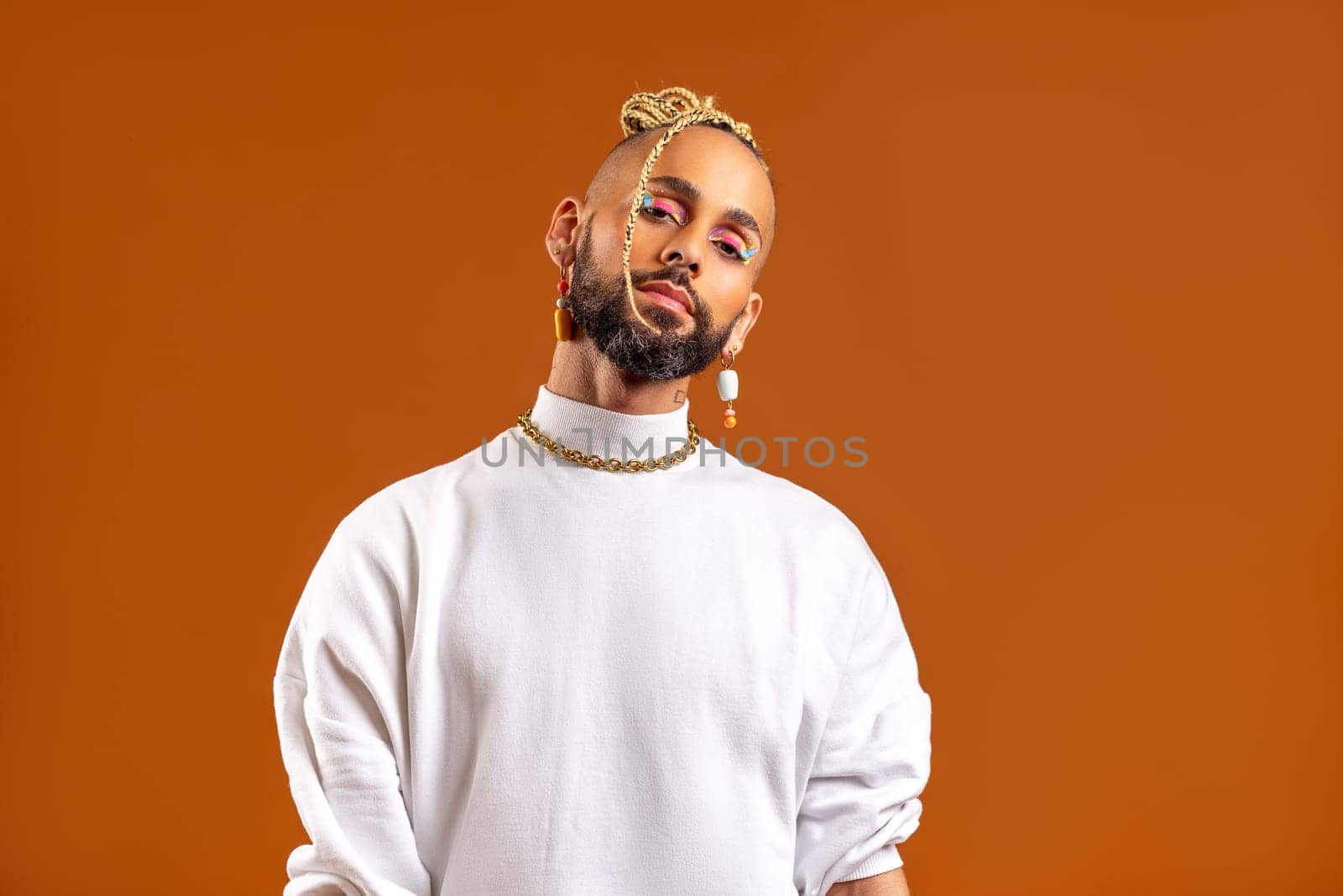 Trendy black latin gay man in white clothes look camera isolated on orange background studio portrait People lifestyle fashion lgbtq concept