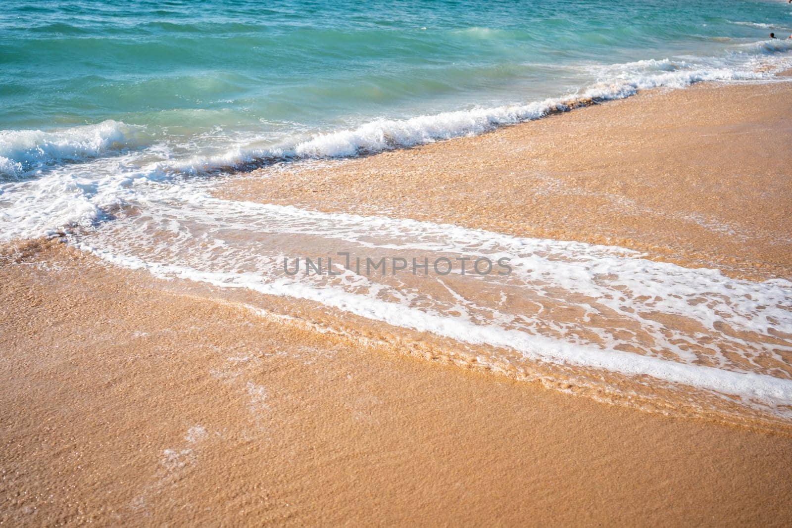 Soft beautiful ocean wave on sandy beach. Background. Turquoise color sea view with copy space