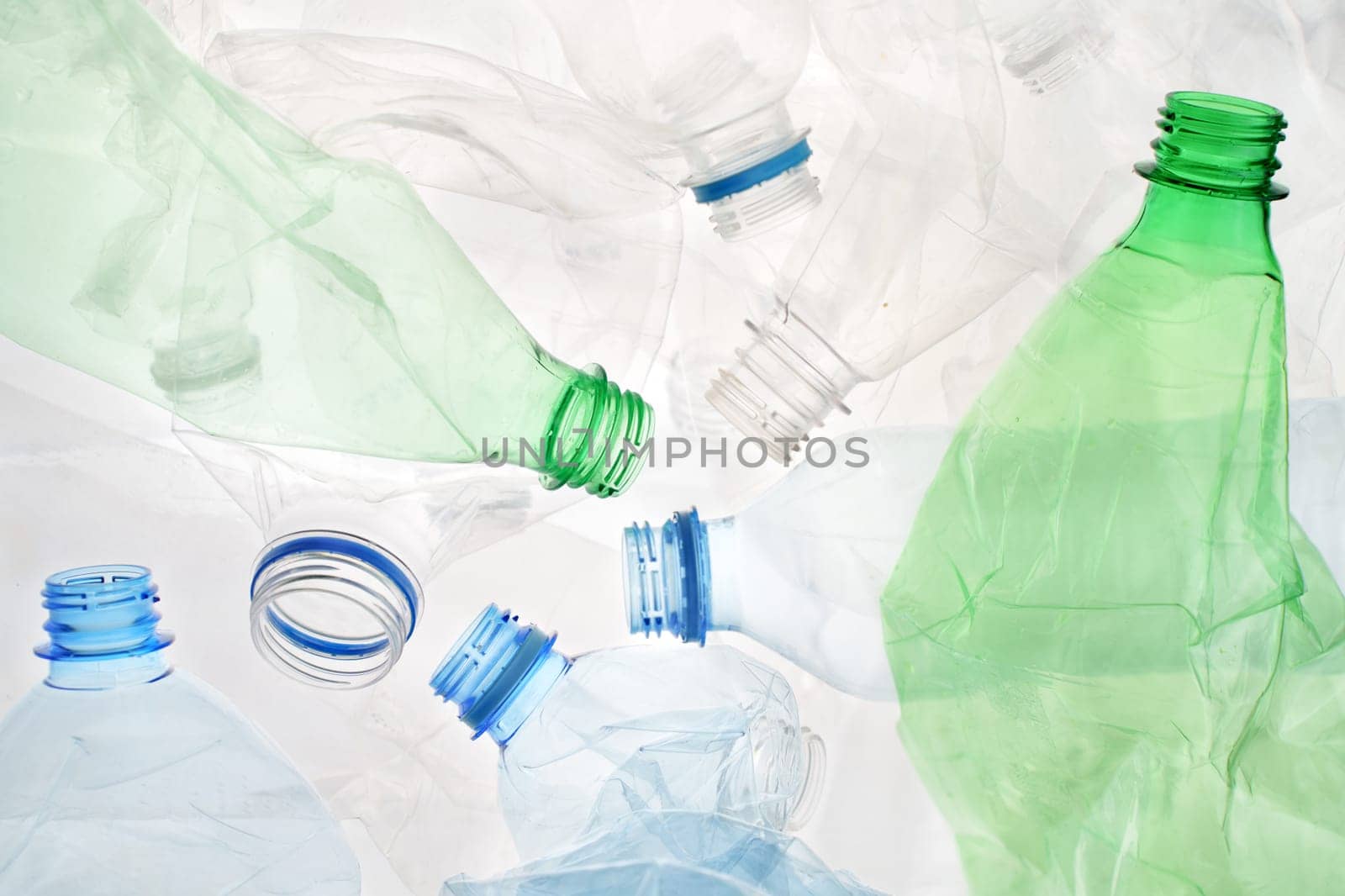 Transparent plastic bottle crumpled plastic recycling waste sorting. Pile of bottles PET recycling bottles background. Crushed bottle smashed plastic background. Recyclable materials. Disposable. Used by synel