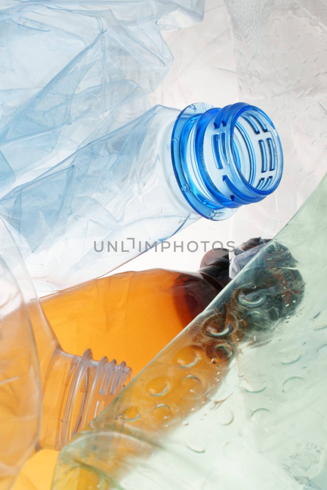 Transparent plastic bottle crumpled plastic recycling waste sorting. Pile of bottles PET recycling bottles background. Crushed bottle smashed plastic background. Recyclable materials. Used. Disposable