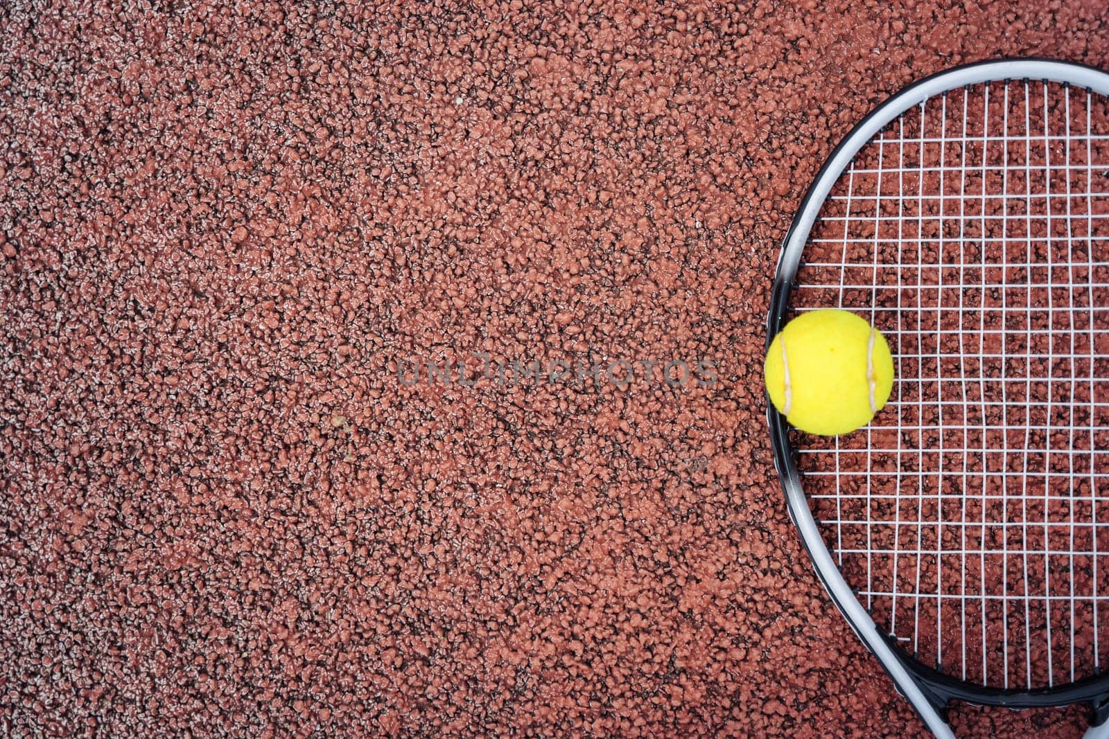 Closeup top view on tennis ball and racket racquet lying on acrylic tennis hard court surface with empty blank copy space by Ostanina