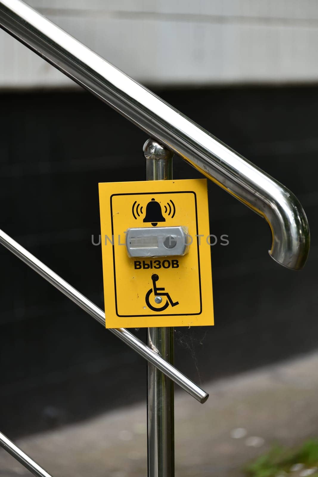 Button for calling help for the disabled on the handrail of the stairs