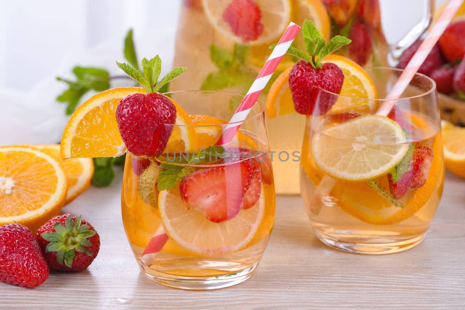 Summer Sangria cocktail or lemonade with strawberry, orange and mint. Refreshing organic non-alcoholic, Detox vitaminized healthy drink, fruit in a glass