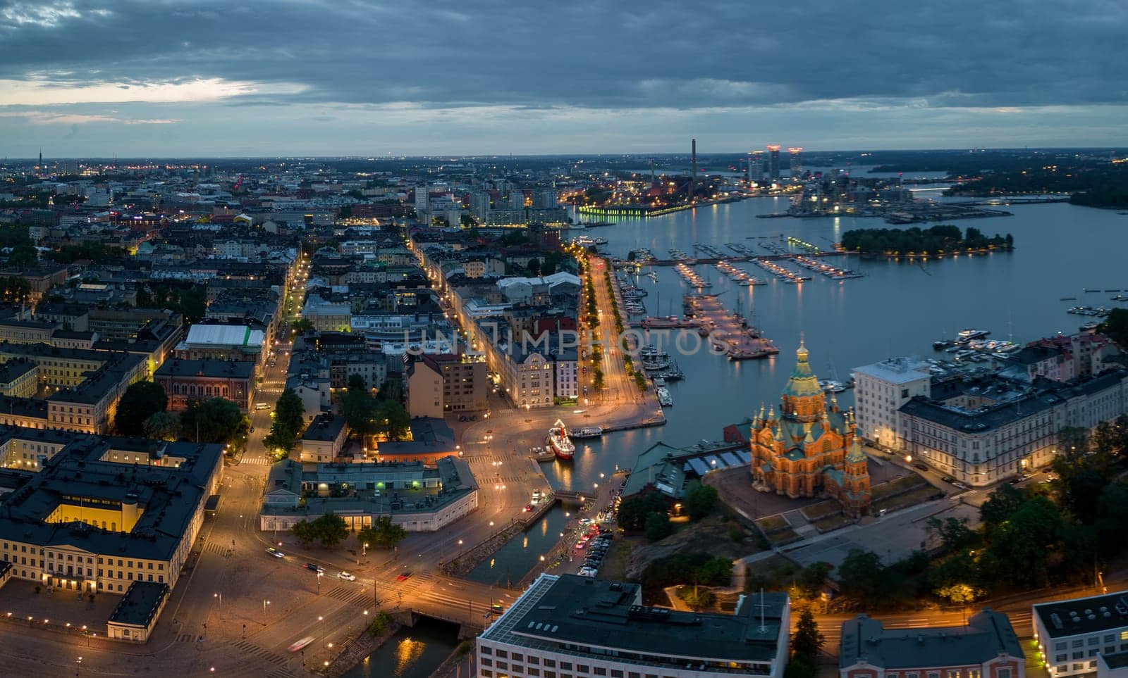 View of Uspenski Cathedral and buildings by lit streets and harbor at dawn. High quality photo