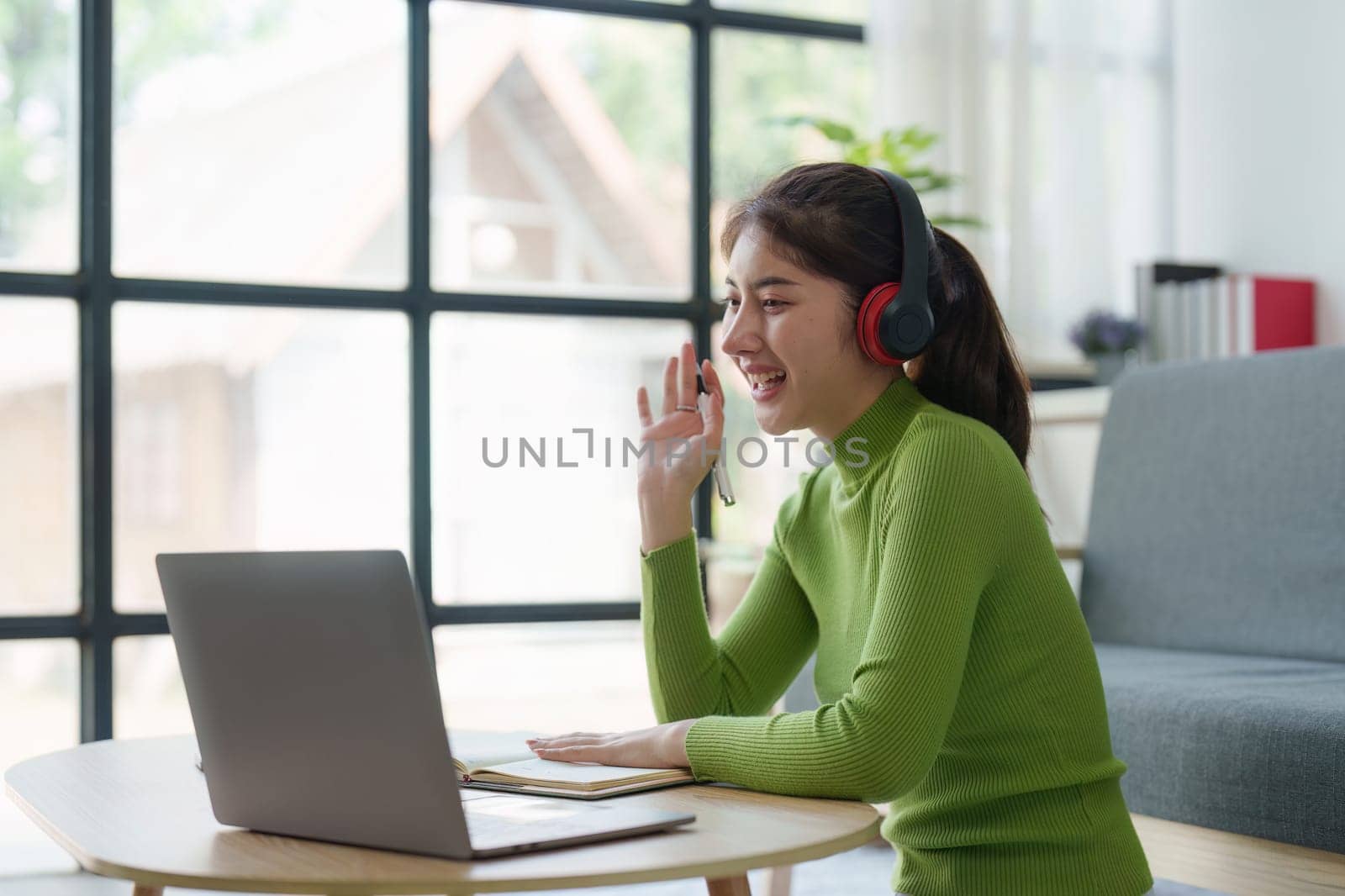 Young asian relaxed smiling pretty woman relaxing with laptop at home. Female feeling joy enjoying with mobile phone on cozy couch.