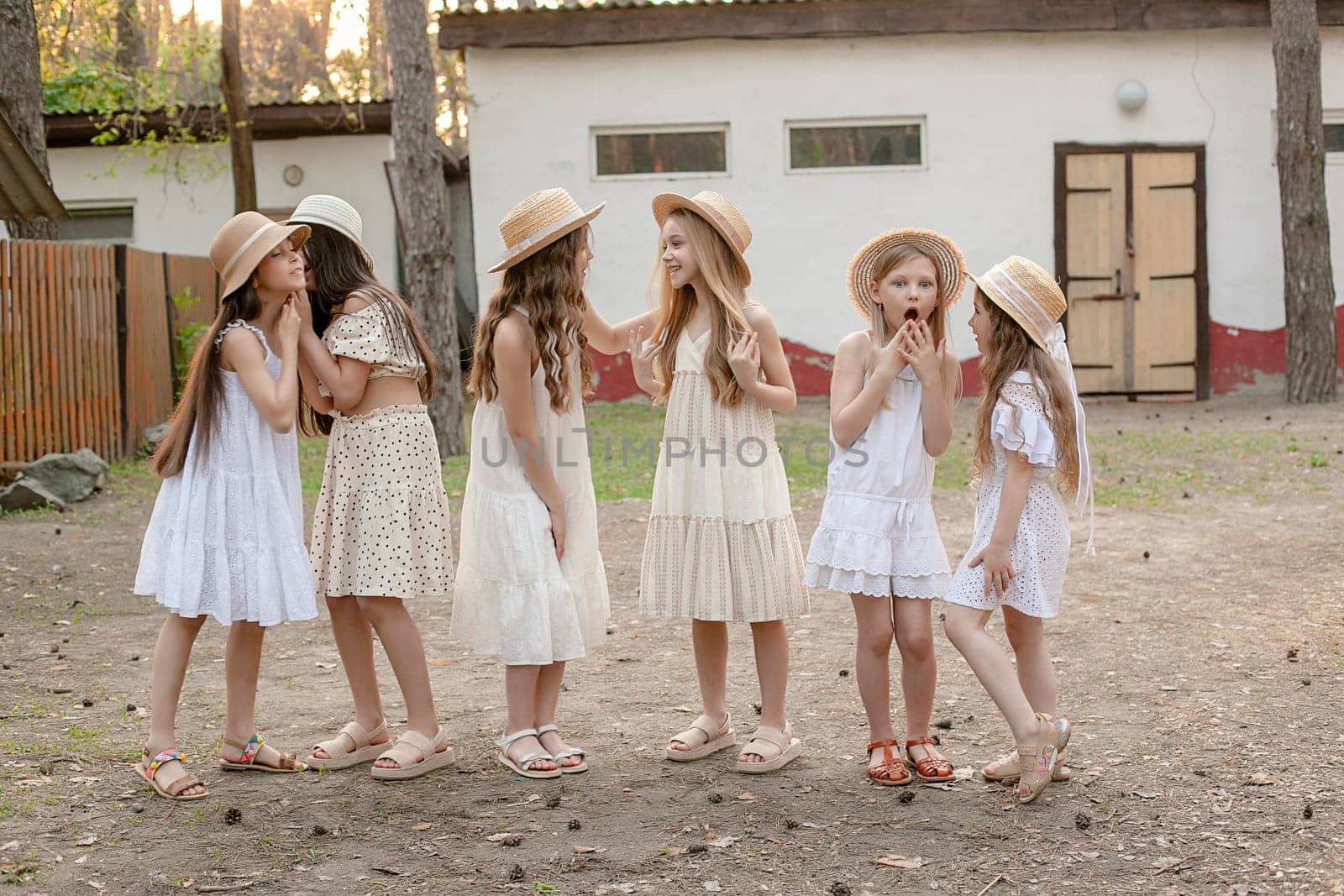 Group of emotional preteen girls hatting on courtyard of country estate by nazarovsergey