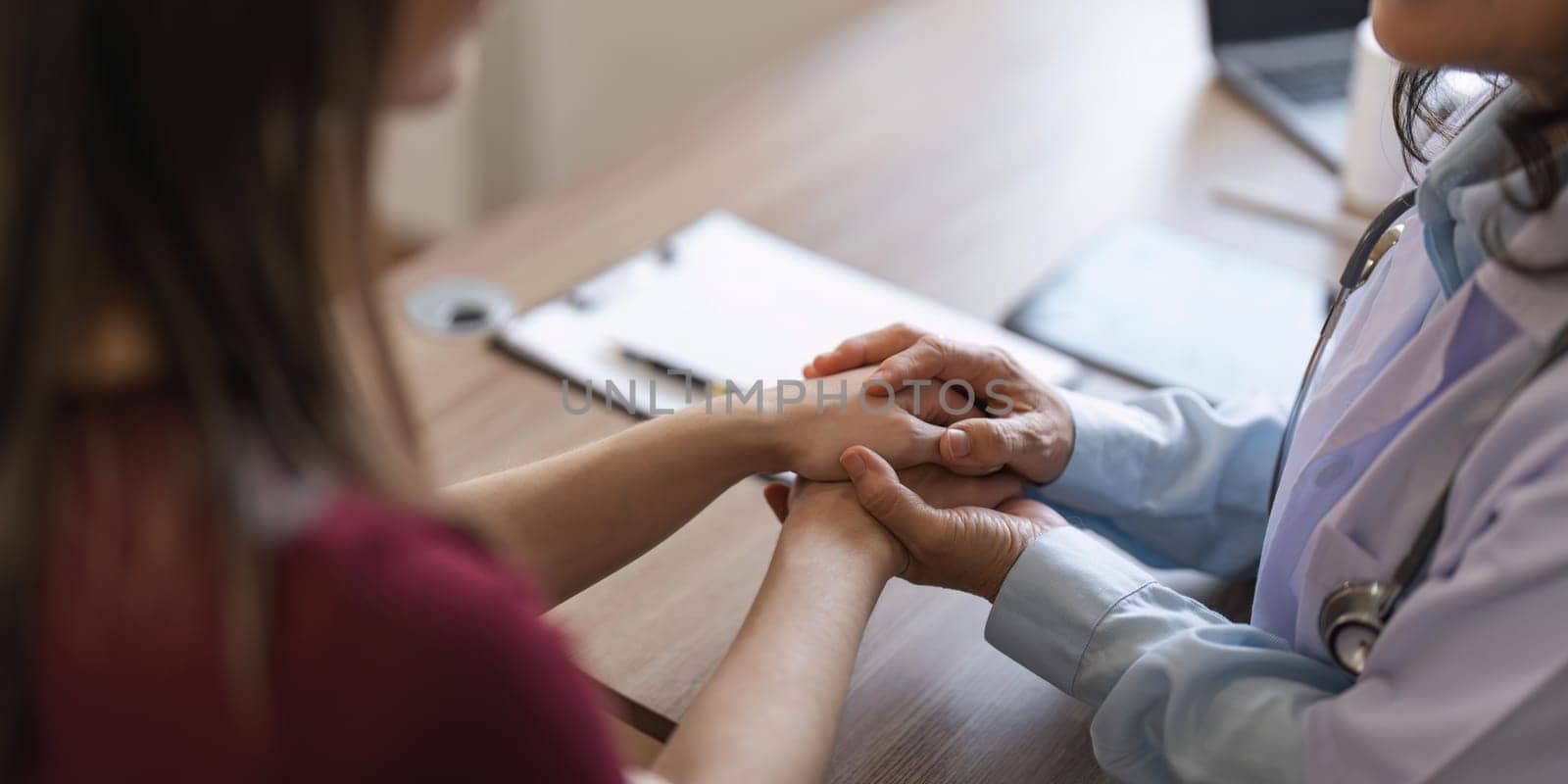 Happy woman visiting doctor senior , getting optimistic news after medical checkup, therapy. Therapist holding hand of patient, giving hope, support, congratulating on goor treatment result.