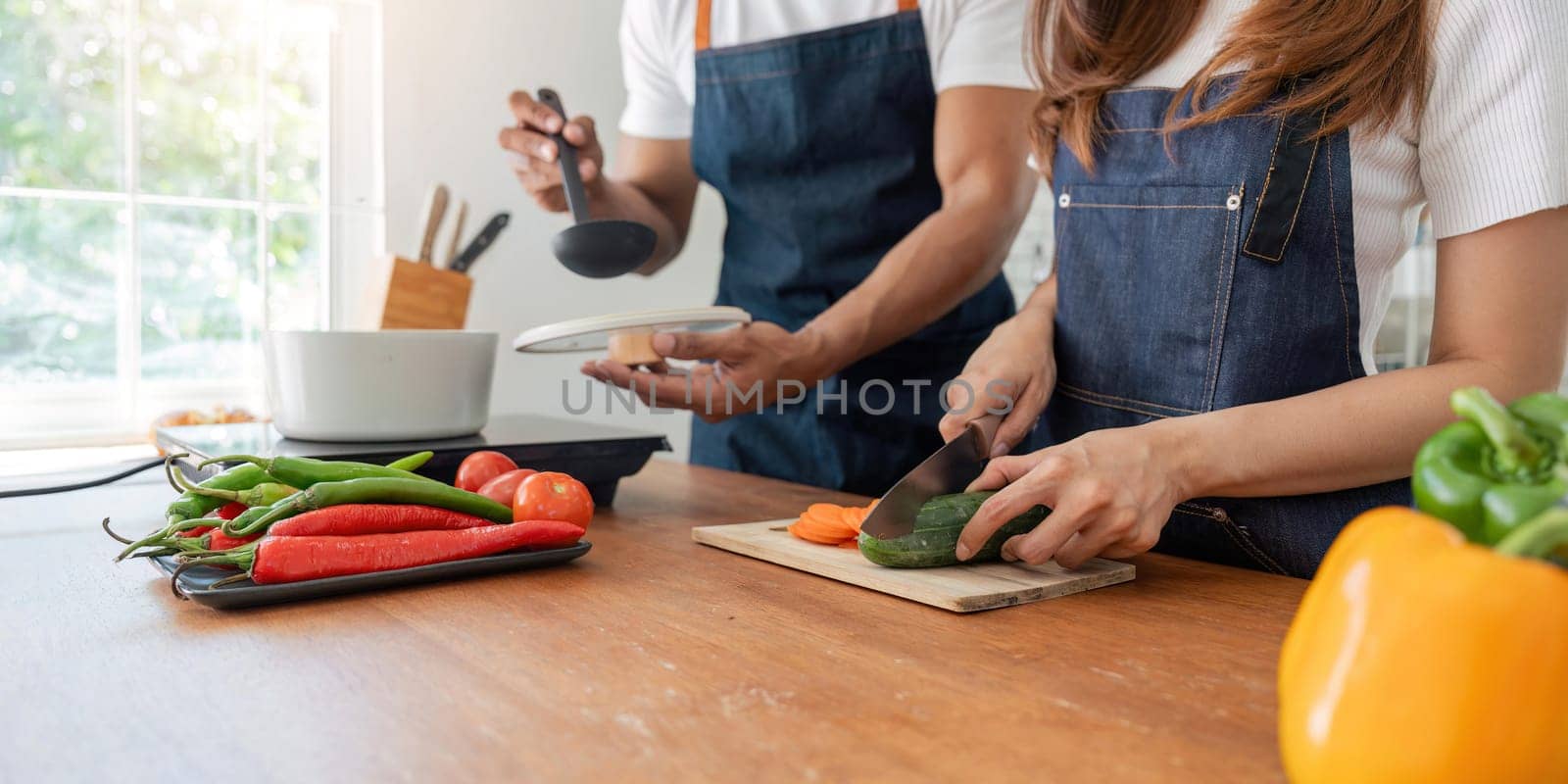 Young couple is while cooking together in kitchen at home by nateemee