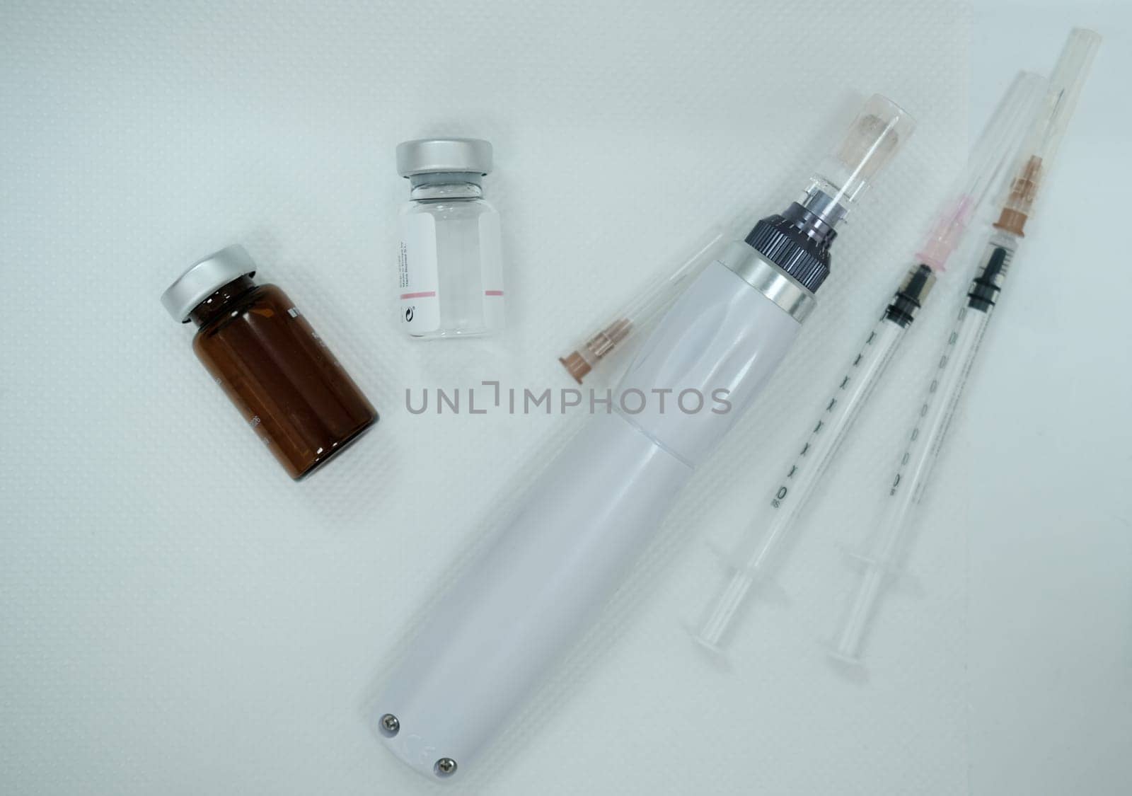 Equipment after microneedling procedure. Syringes. Serum bottle. Dermapen device. Microneedling device