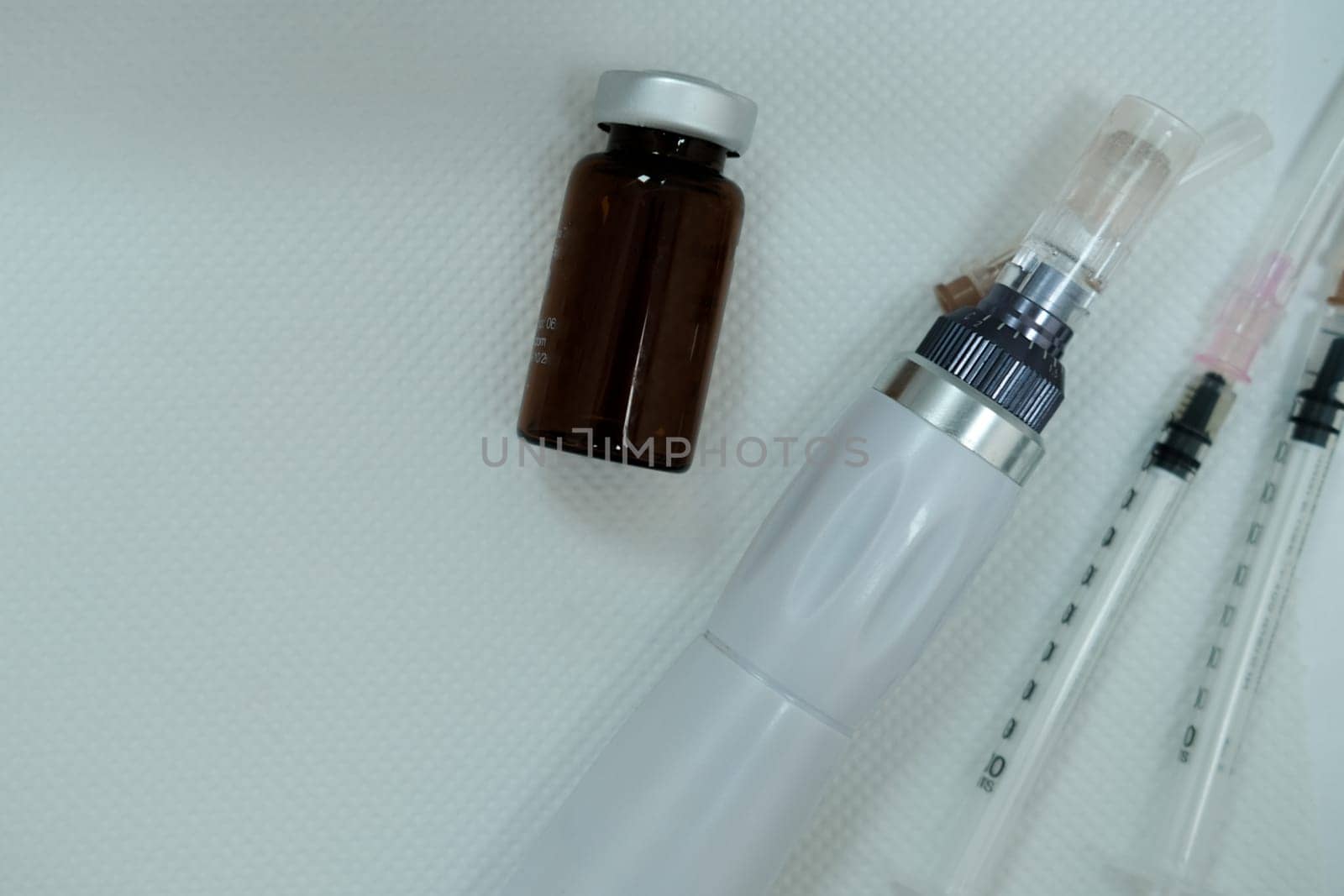 Equipment after microneedling procedure. Syringes. Serum bottle. Dermapen device. Microneedling device