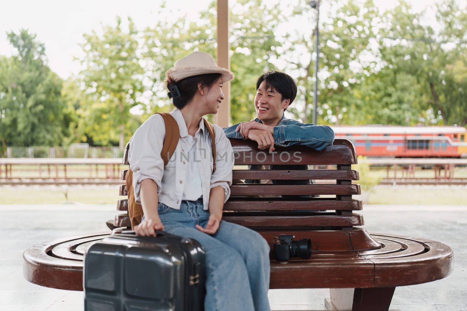 Asian couple at railway station have happy moment. Tourism and travel in the summer.