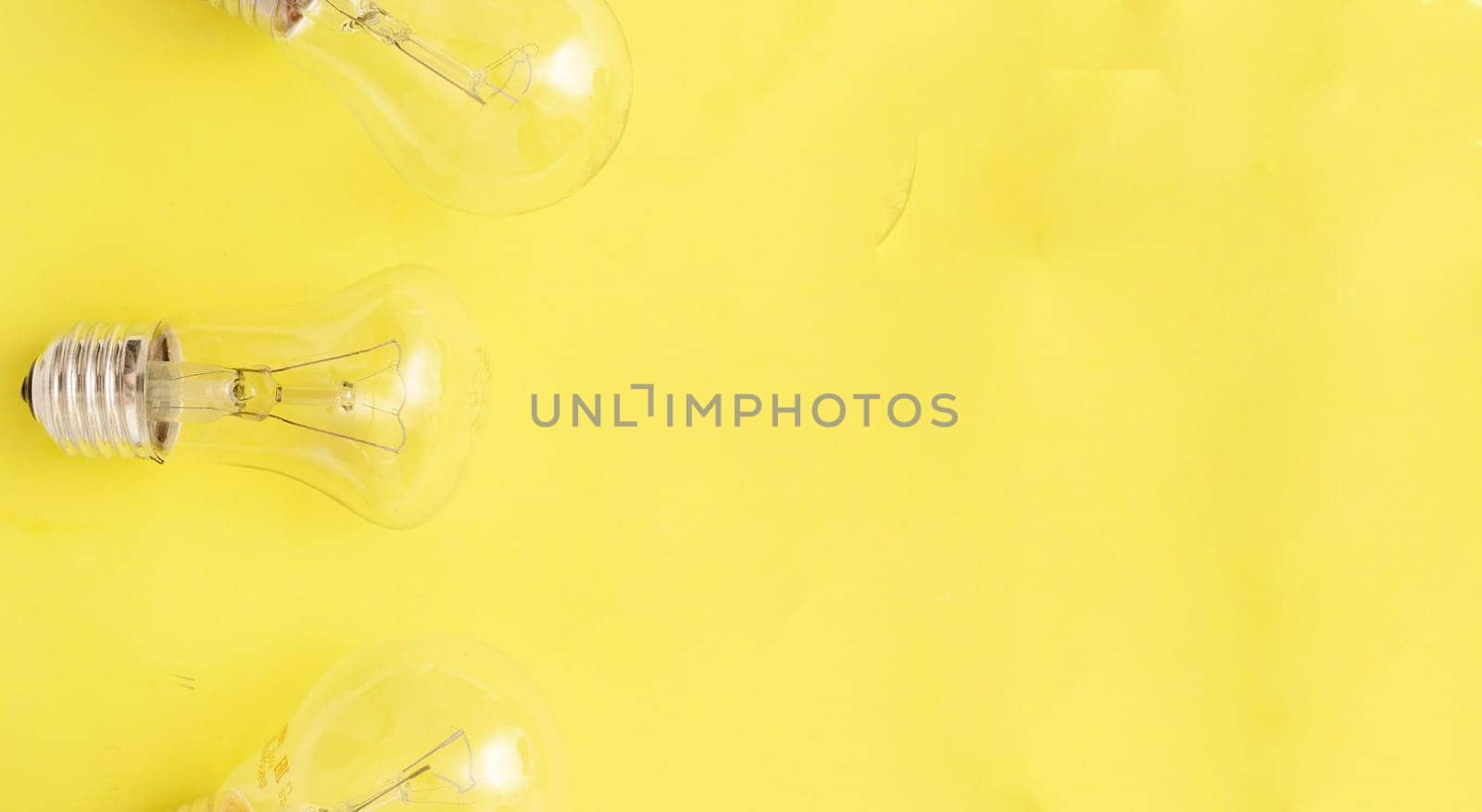 incandescent lamps on yellow background, copyspace