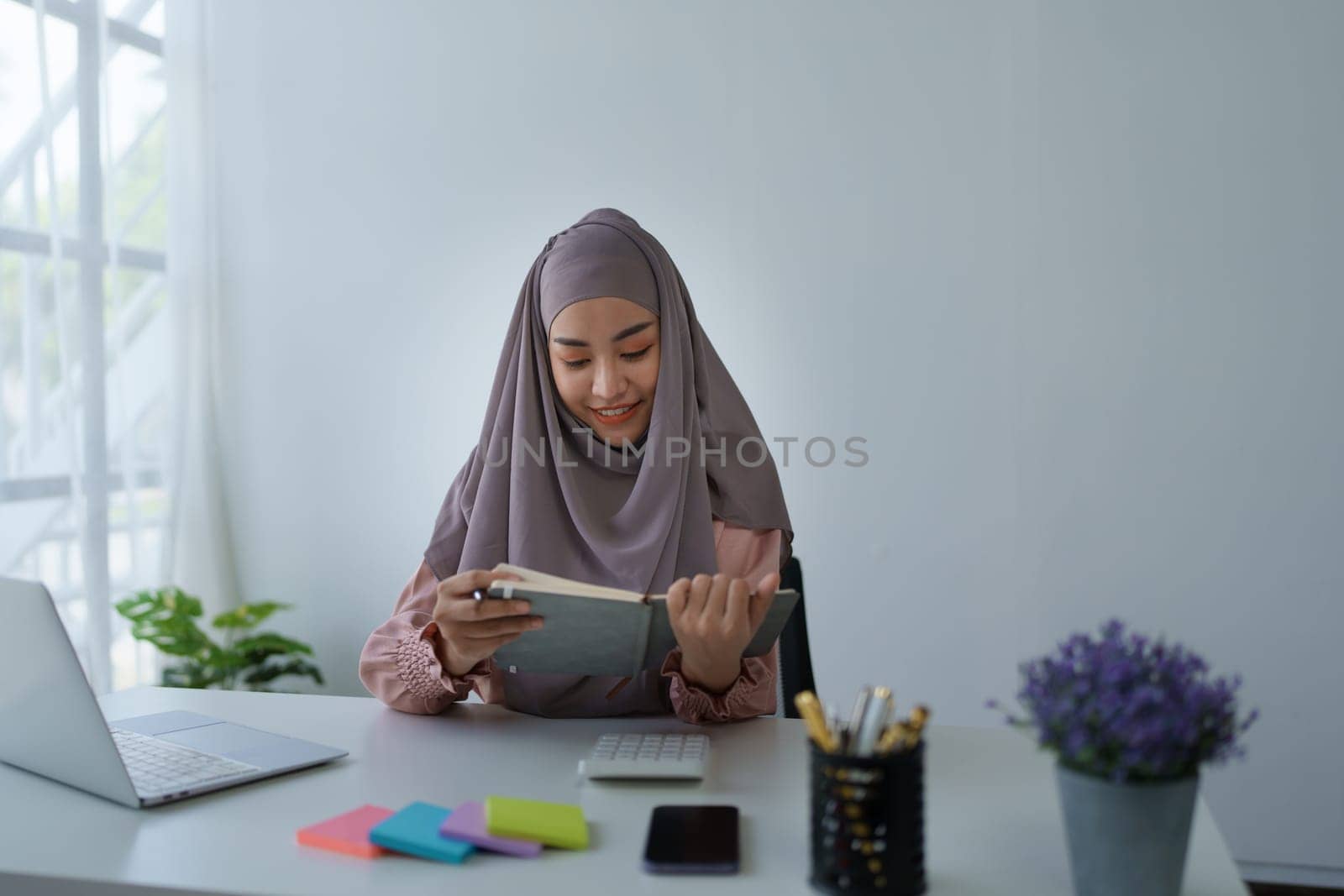 financial, Planning, Marketing and Accounting, portrait of Muslim woman employee checking financial statements using documents and calculators at work by Manastrong