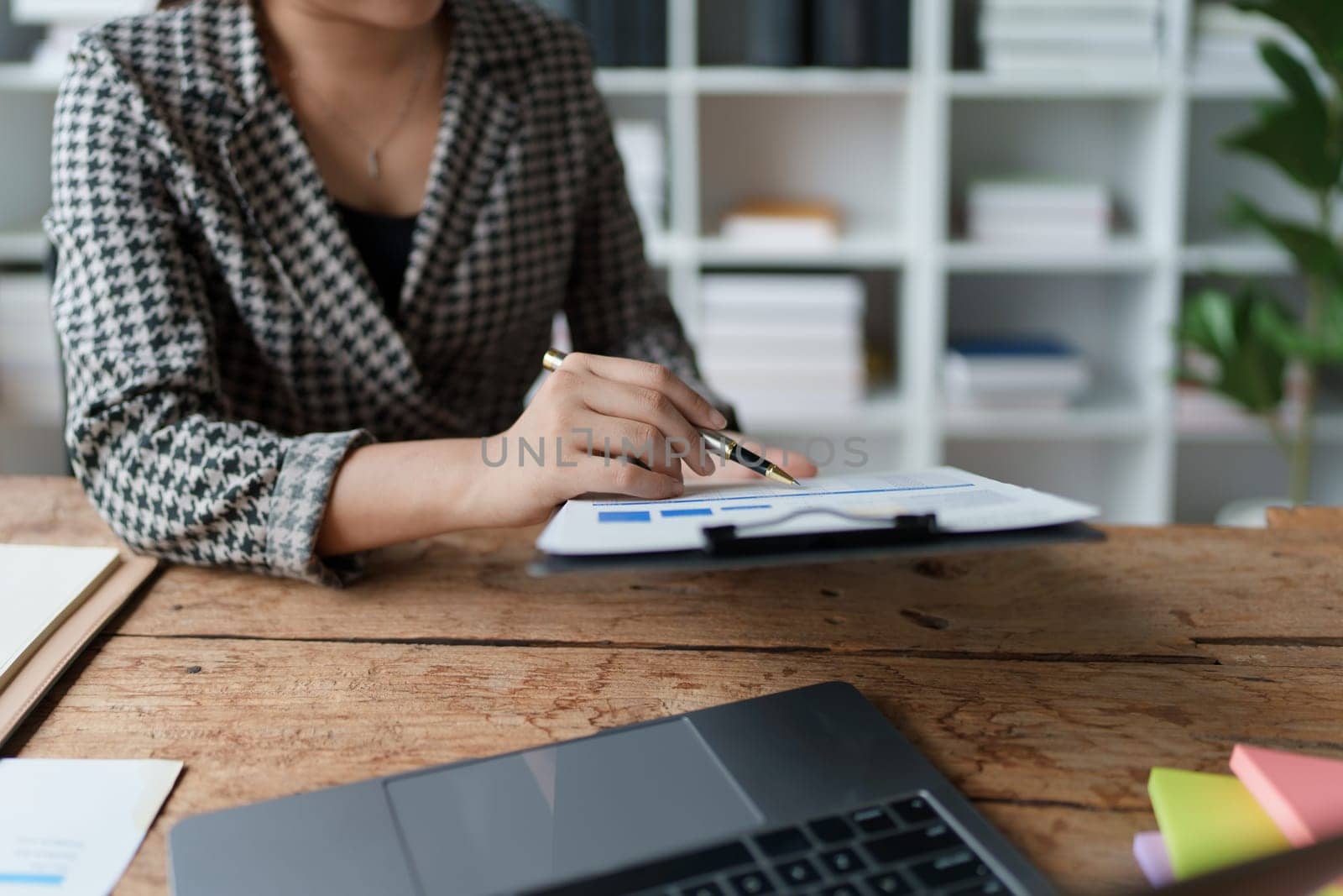 financial, Planning, Marketing and Accounting, portrait of Asian employee checking financial statements using documents and calculators at work by Manastrong