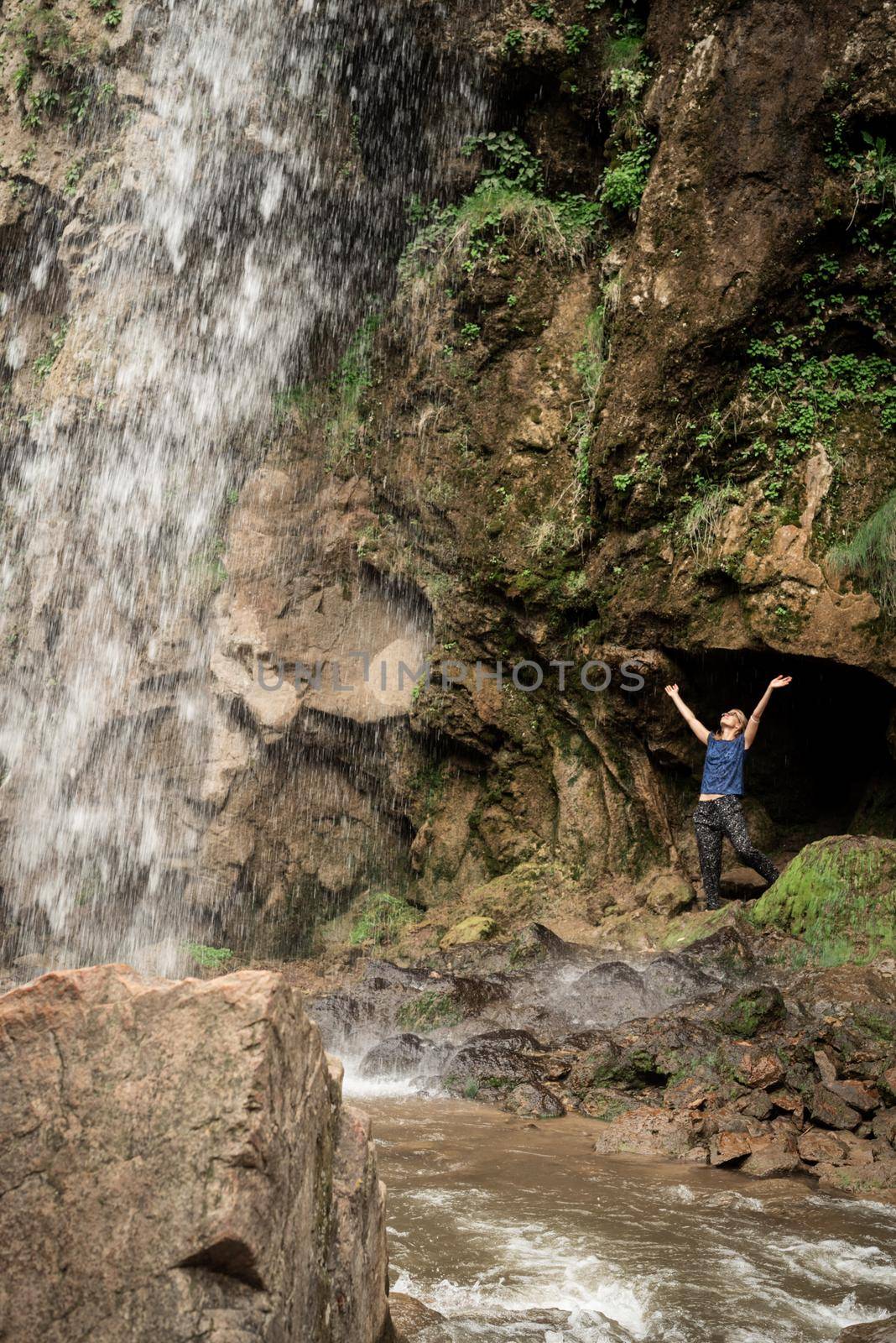 Small human watching at beautiful mountain waterfall by Desperada