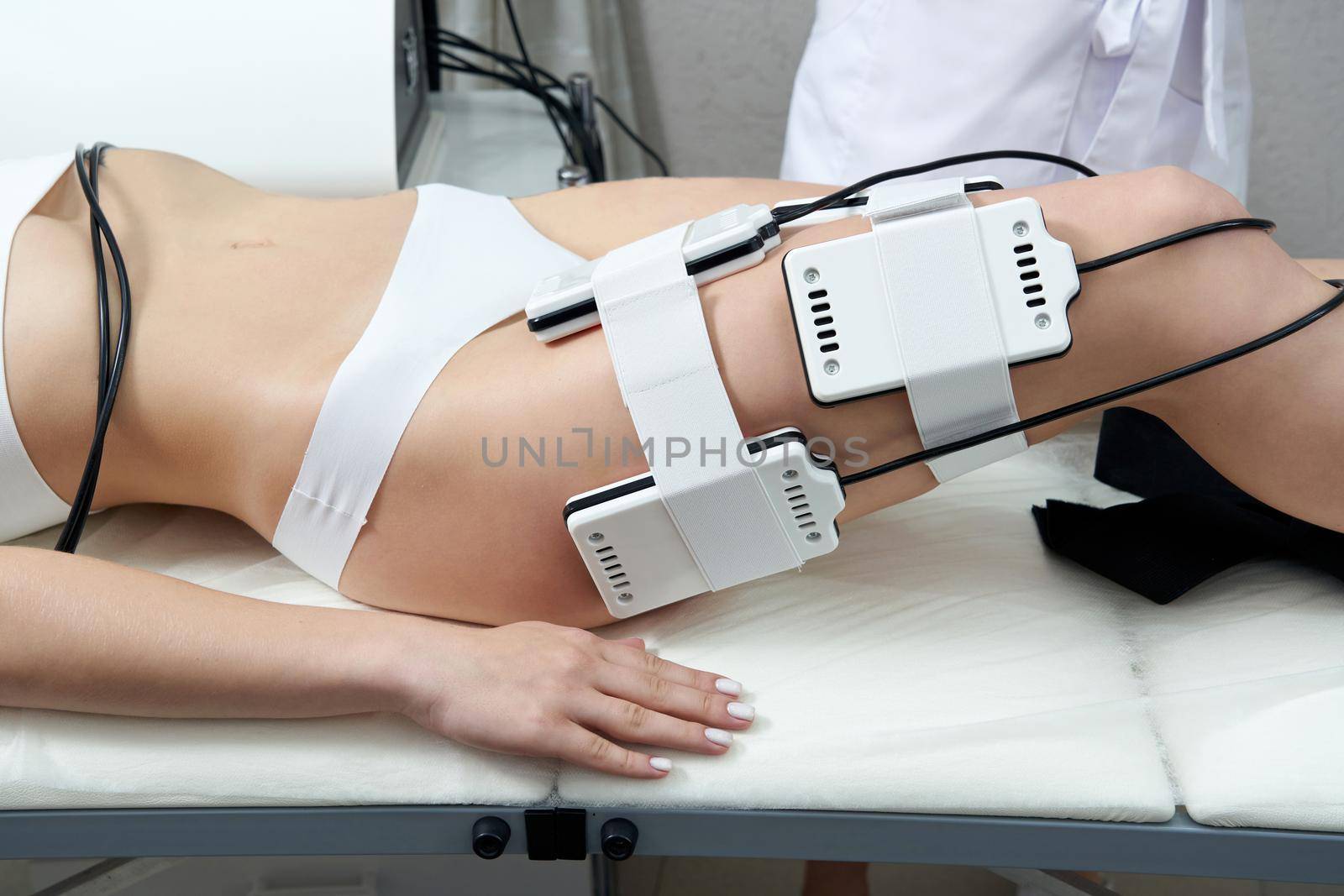 Beautiful woman getting electro stimulation therapy. Laser lipo equipment. Cosmetic fat reduce treatment. Woman in medicine salon. Anti cellulite procedure.