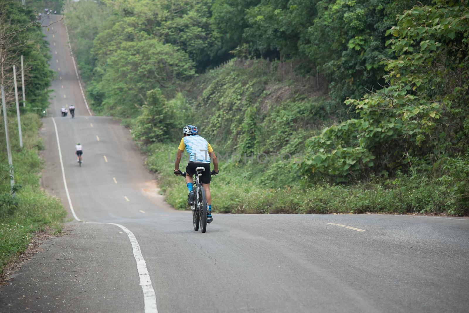 man riding bicycle on the road by Wmpix