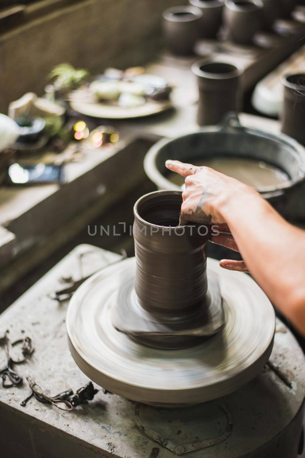Closeup potter's hands shaping soft clay to make an earthen pot